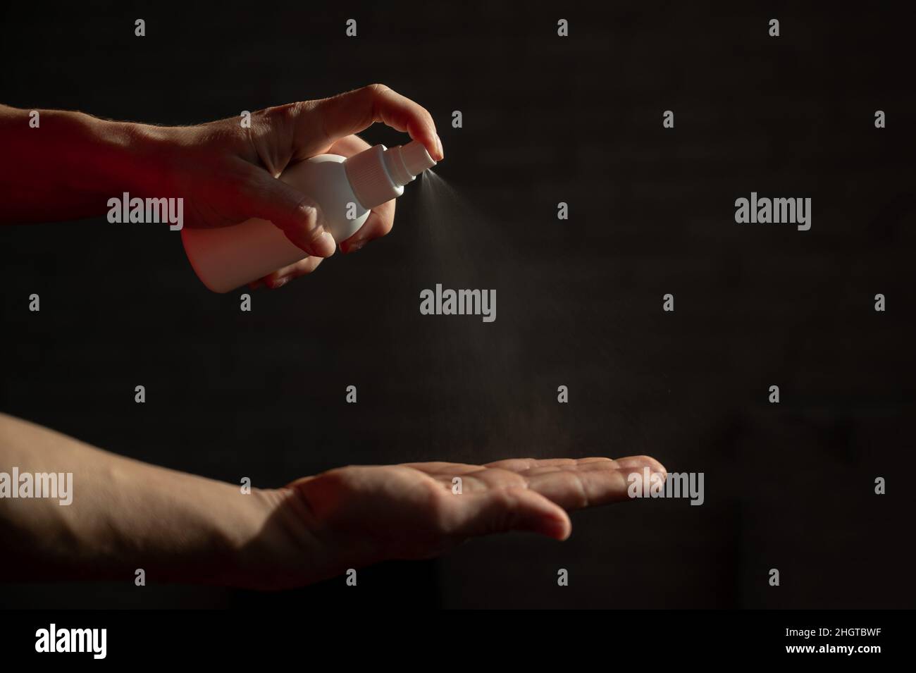 Weibliche Hände Nahaufnahme mit antiseptischem Spray. Eine Frau zur Vorbeugung von Coronaviren sprüht ein antibakterielles Mittel in ihre Handfläche. Stockfoto