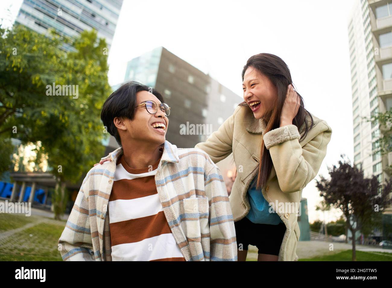 Glücklich lächelndes asiatisches Paar, das Spaß hat und sich anschaut. Junge Liebhaber machen Urlaub. Jugendkultur und Stadtleben. Stockfoto
