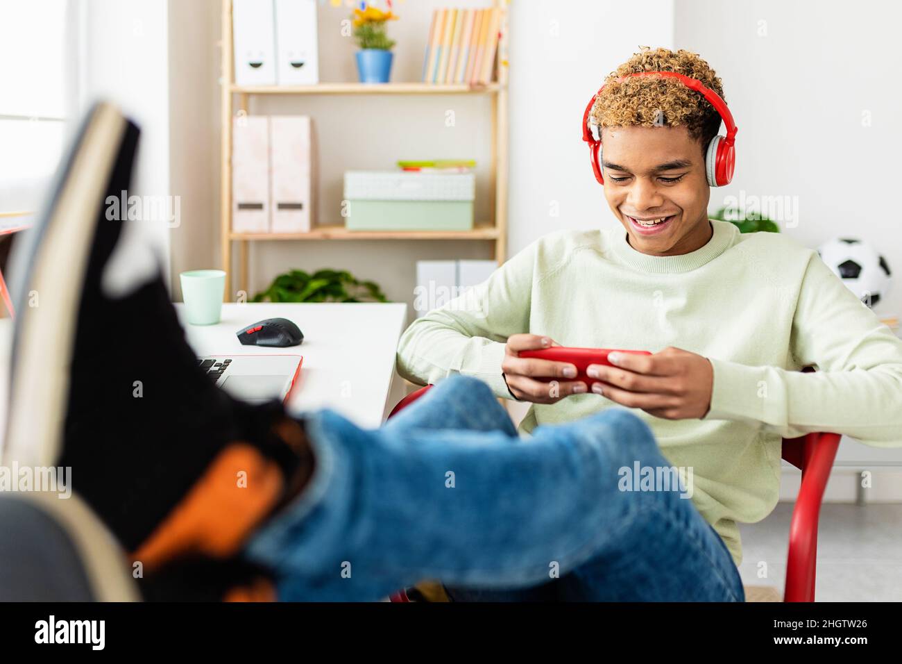 Süchtiger junger Teenager, der zu Hause Videospiele auf der Handy-App spielt Stockfoto