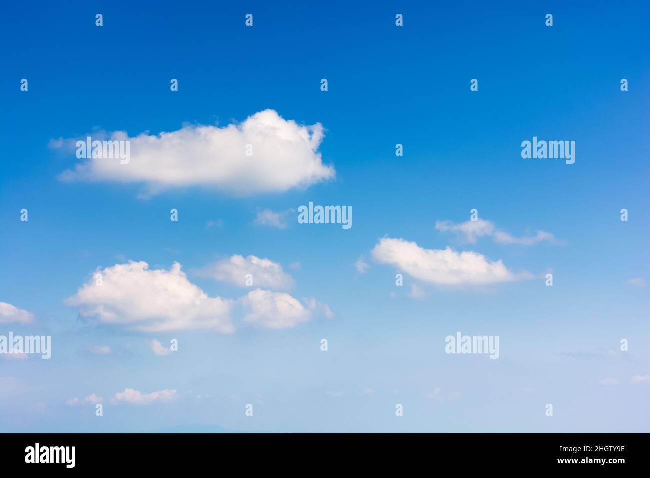 Himmel mit flauschigen Wolken. Weißer Cumulus spärliche Wolkenlandschaft auf einem tiefblauen Gefälle der Atmosphäre. Sonniges Sommerwetter. Schöner Naturhintergrund. Mete Stockfoto