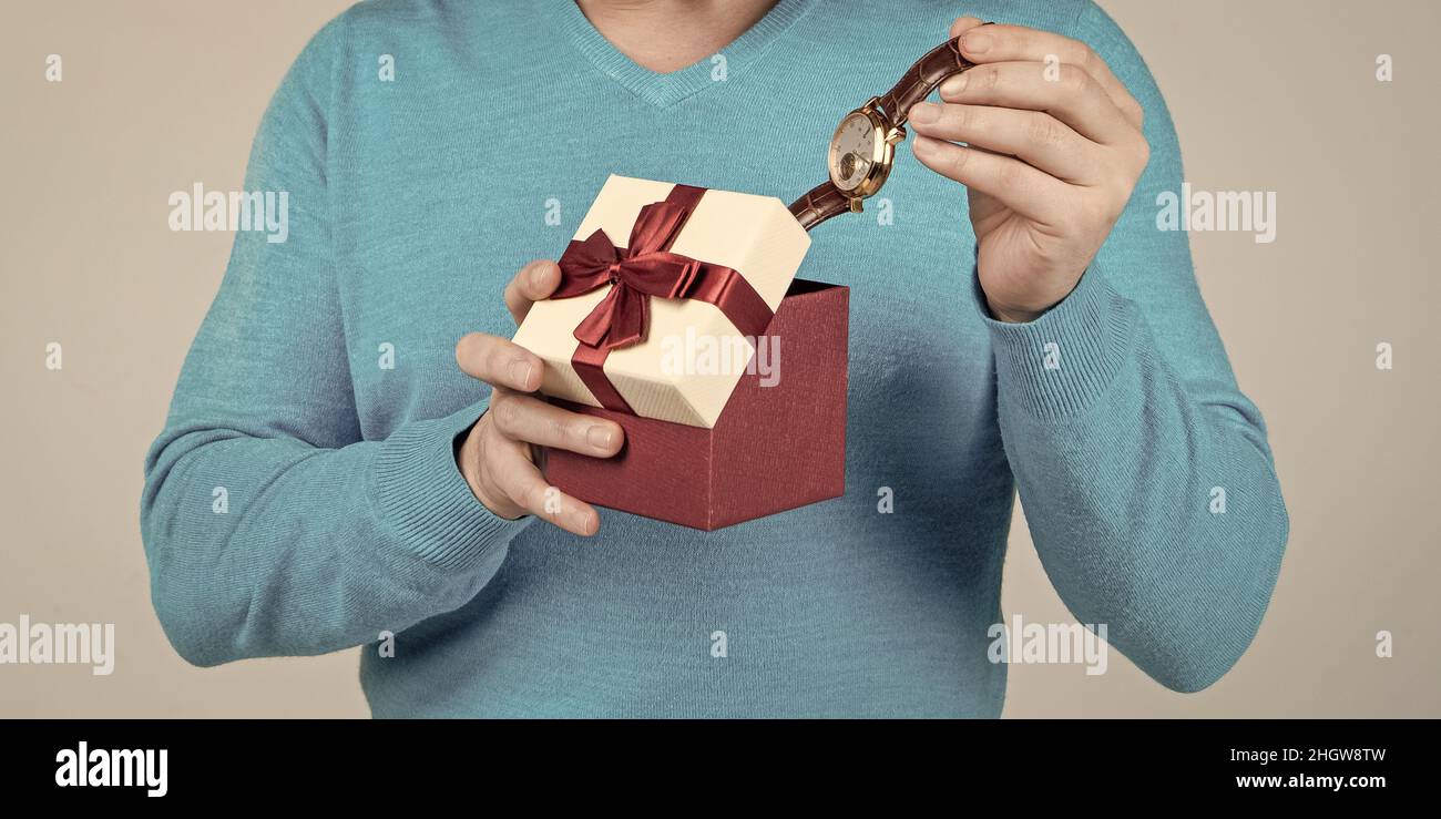 Armbanduhr in Geschenk-Box in der Hand des kurzbeschnittenen Mannes, Herrentag Stockfoto