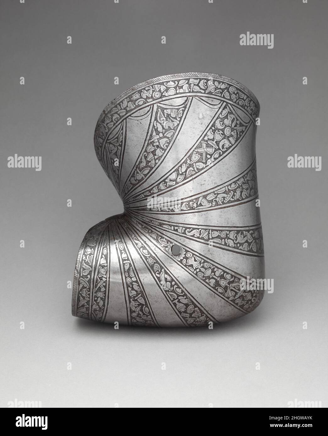 Große Ellenbogenverstärkung (Pasguard oder Soprabracciale) ca. 1550 bis 1575 Italienisch dieser große Ellenbogen-Verstärkung (soprabacciale) ist Teil einer ungewöhnlich großen Rüstungsgarnitur (gem 27.159.1) aus der Waffenkammer der Familie Dos Aguas in Valencia, Spanien. Die Garnitur enthält Stücke für den Einsatz im Kampf und für die Neigung in der italienischen und deutschen Mode. Der Tilt war ein Turnier, das auf dem Pferderücken zwischen zwei Gegnern ausgetragen wurde, die mit Lanzen bewaffnet und durch eine längs abtrennte Barriere getrennt waren.die Rüstung ist mit einem Helm und einer Armstütze (Armverteidigung) für das Turnier ausgestattet. Die Puffe (Kinnabwehr), sek Stockfoto