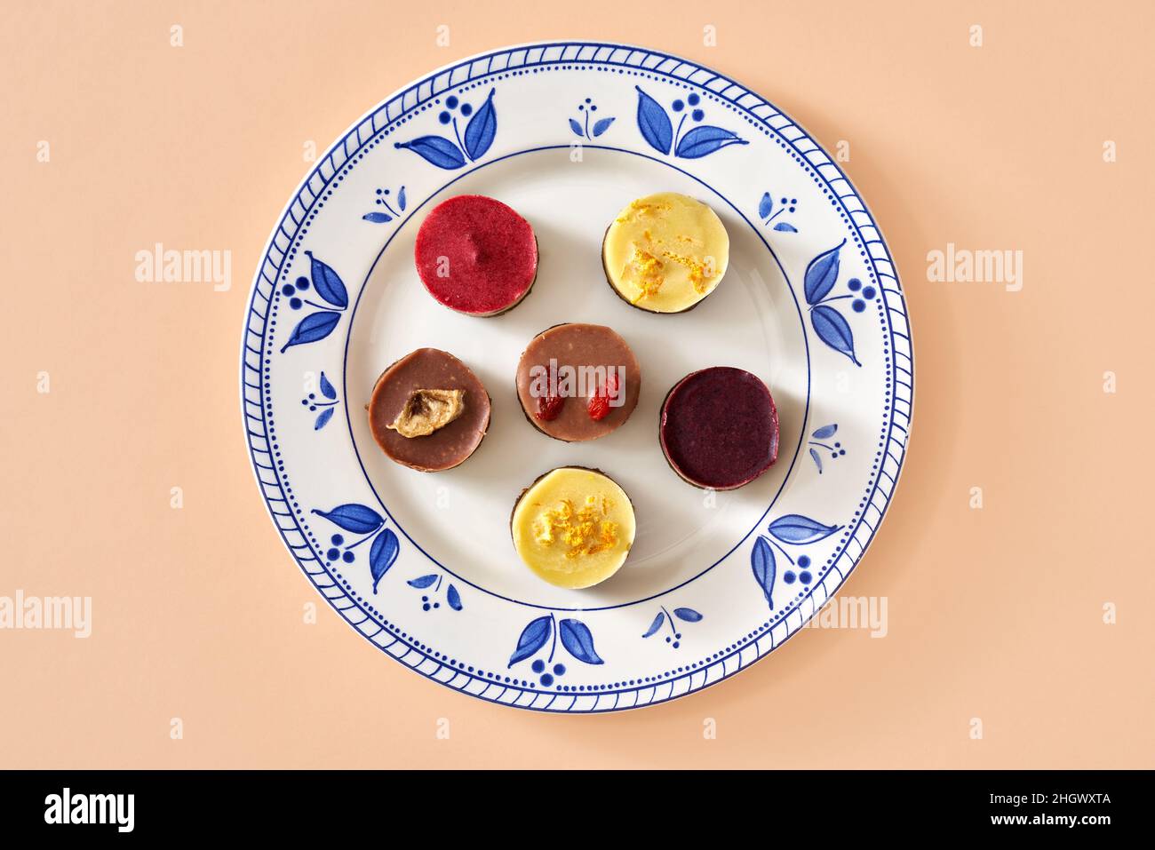 Heidelbeere, Himbeere, Goji, Zitrone und Banane rohe vegane Mini-Desserts auf einem Teller, Draufsicht Stockfoto