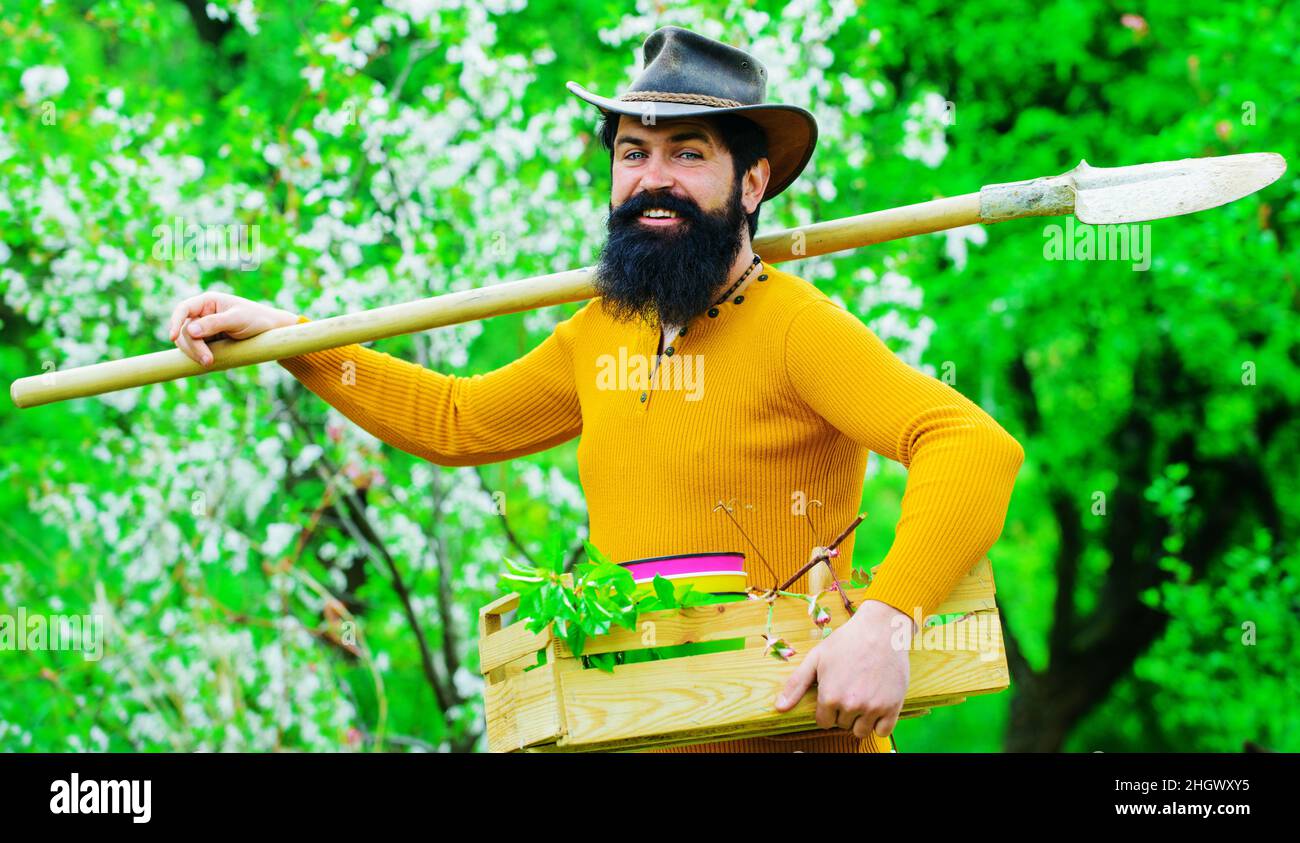 Öko-Farm. Männlicher Bauer arbeitet im Garten. Frühjahrsfarmen. Bärtiger Gärtner mit Gartengeräten. Stockfoto