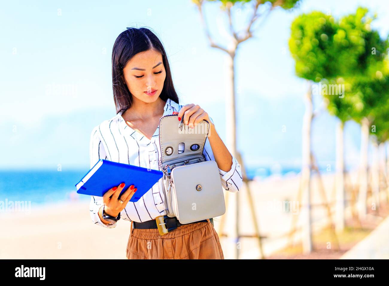 Bild einer geschäftigen asiatischen Frau im Freien an sonnigen Sommertagen Stockfoto