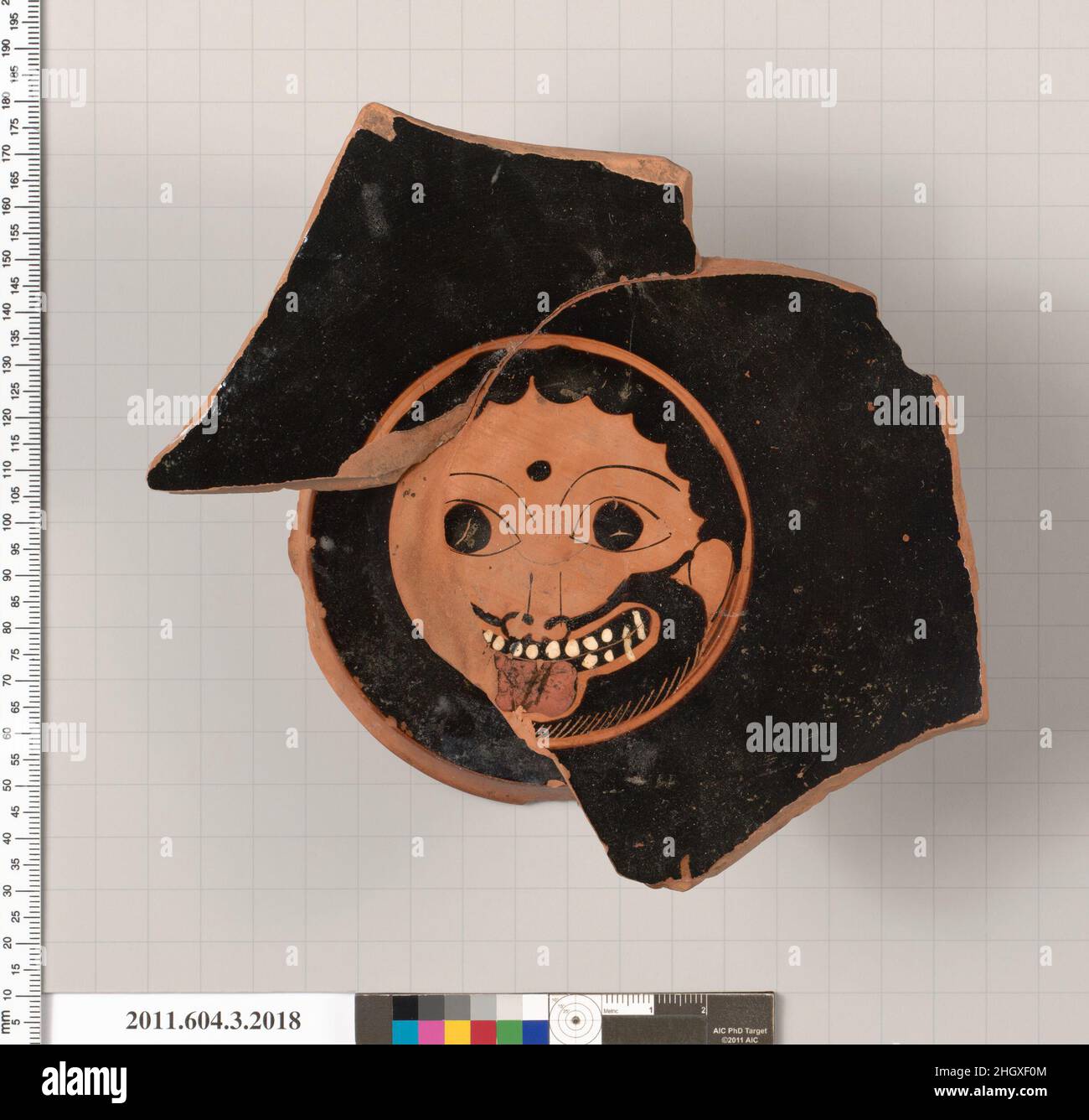 Terrakotta-Fragment einer Kylix: Augenbecher (Trinkbecher) drittes Viertel des 6th. Jahrhunderts v. Chr. Griechisch, Dachboden, Teil des Gesichts einer Gorgoneion mit einem Punkt zwischen den Augenbrauen; Außen, ein Paar Augen und eine Nase; Reben mit Trauben; An der Stelle von Schale und Spitze des Stiels ein rot glasierter Ring; der äußere Rand des Fußes ist konkav und unglasiert; die ruhende Oberfläche ist unglasiert; die obere Hälfte der Innenseite des Stiels ist unglasiert; die untere Hälfte ist glasiert. Terrakotta-Fragment einer Kylix: Augenbecher (Trinkbecher). Griechisch, Dachboden. Drittes Viertel des 6th. Jahrhunderts B.C. Terracot Stockfoto