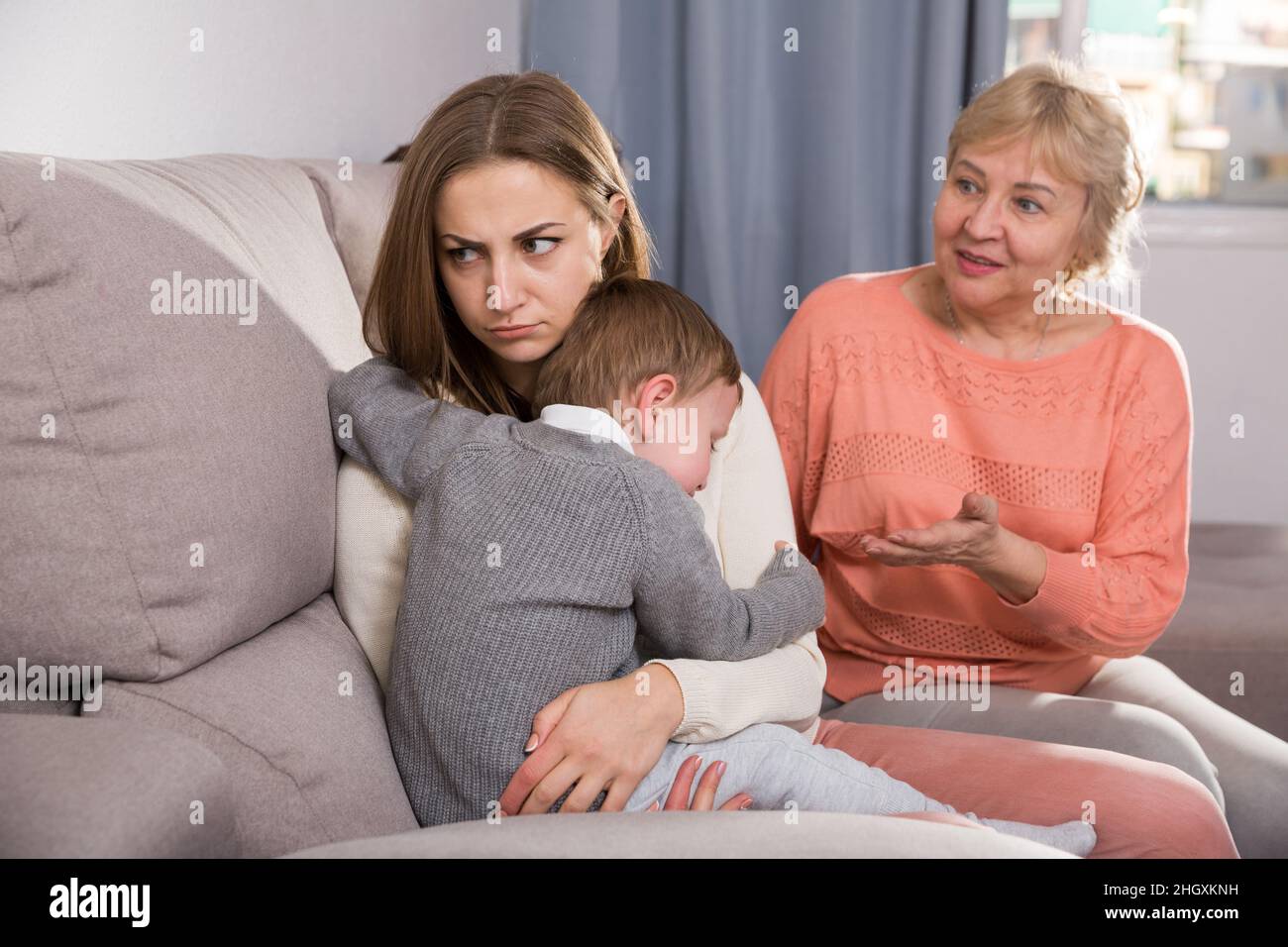 Erwachsene Frauen mit ihrer Mutter haben Meinungsverschiedenheiten über die Elternschaft des Kindes Stockfoto