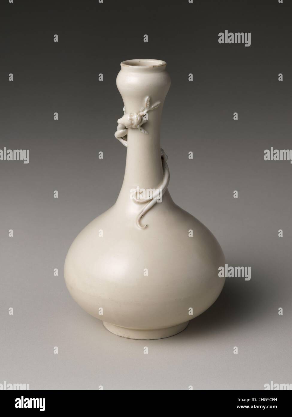 Flasche mit Wickeldrachen Ende des 16th. Jahrhunderts China Archäologische Beweise deuten darauf hin, dass die Öfen in der Nähe von Dehua in der Provinz Fujian an der südöstlichen Küste Chinas im späten 13. Jahrhundert eröffnet und vom 16. Bis zum 18. Jahrhundert floriert haben. Im 17. Bis 19. Jahrhundert wurden Dehua-Waren, sowohl religiöse Figuren als auch Gegenstände für den Einsatz auf einem Schreibtisch eines Gelehrten, durch dicke, glänzende Glasuren nach Europa exportiert. Sie sind in westlichen Schriften oft unter dem französischen Begriff Blanc de Chine oder „China white“ bekannt, der aus der Wissenschaft des 19. Jahrhunderts stammt. Flasche mit Wickeln Stockfoto