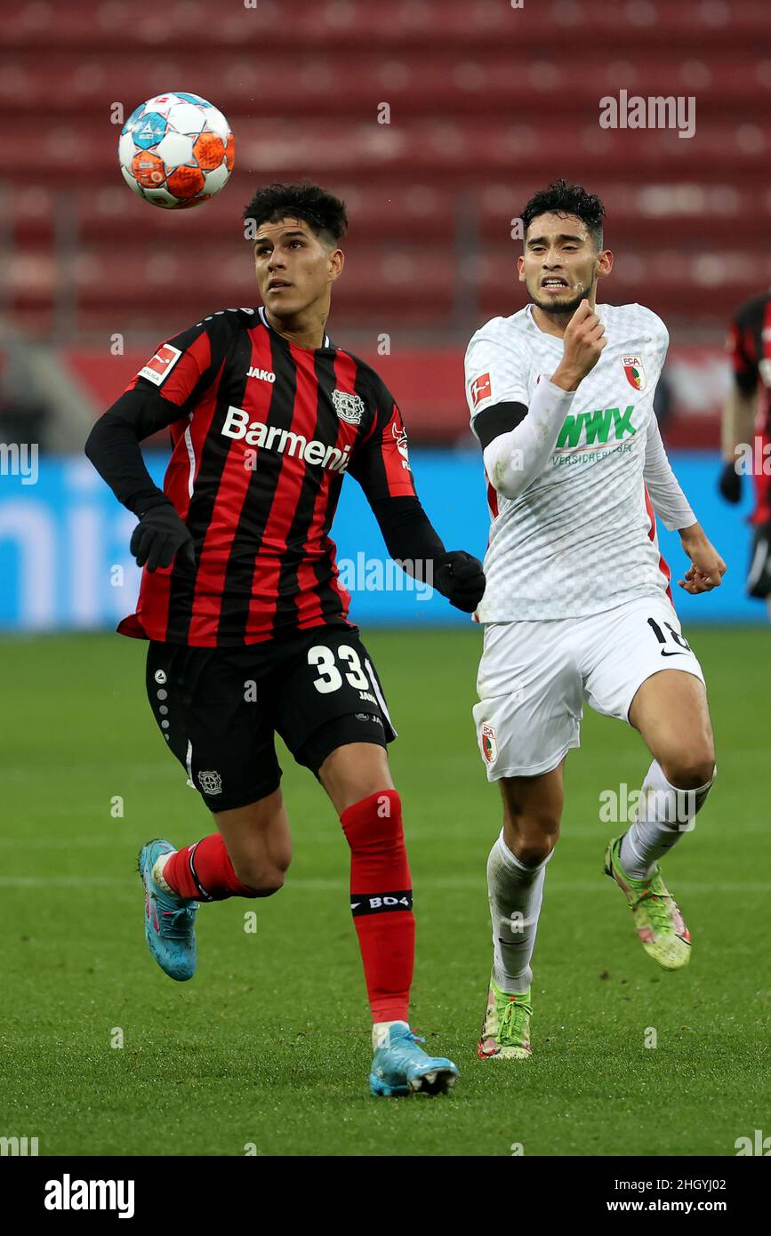 Leverkusen, Deutschland. 22nd Januar 2022. Piero Hincapie (L) aus Leverkusen steht mit Ricardo Pepi aus Augsburg beim Bundesligaspiel der ersten Liga zwischen Bayer 04 Leverkusen und dem FC Augsburg am 22. Januar 2022 in Leverkusen vor. Quelle: Joachim Bywaletz/Xinhua/Alamy Live News Stockfoto