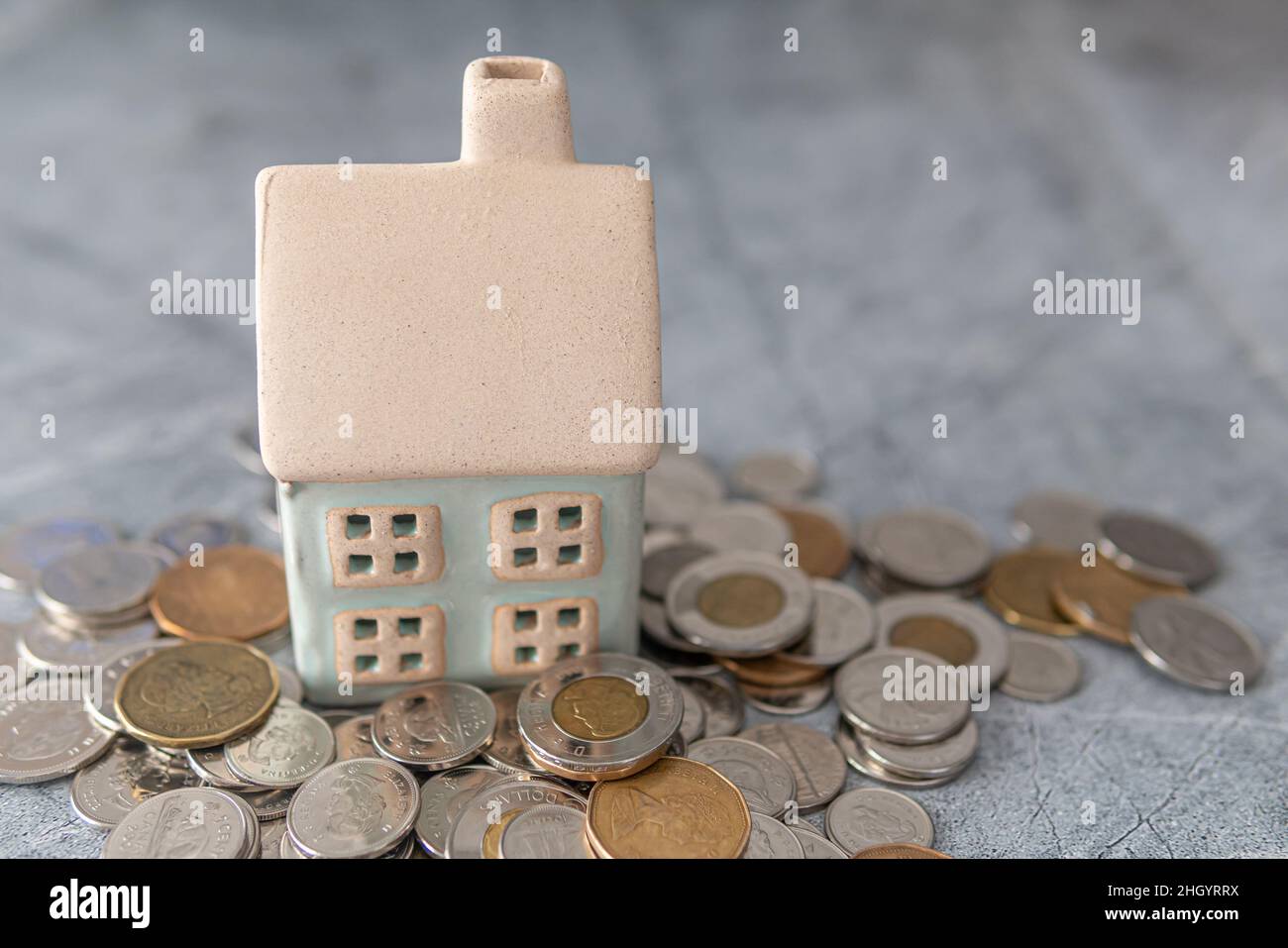 Modellhaus mit Münzstapel - Hausfinanzierung Hypothekenkonzept Stockfoto