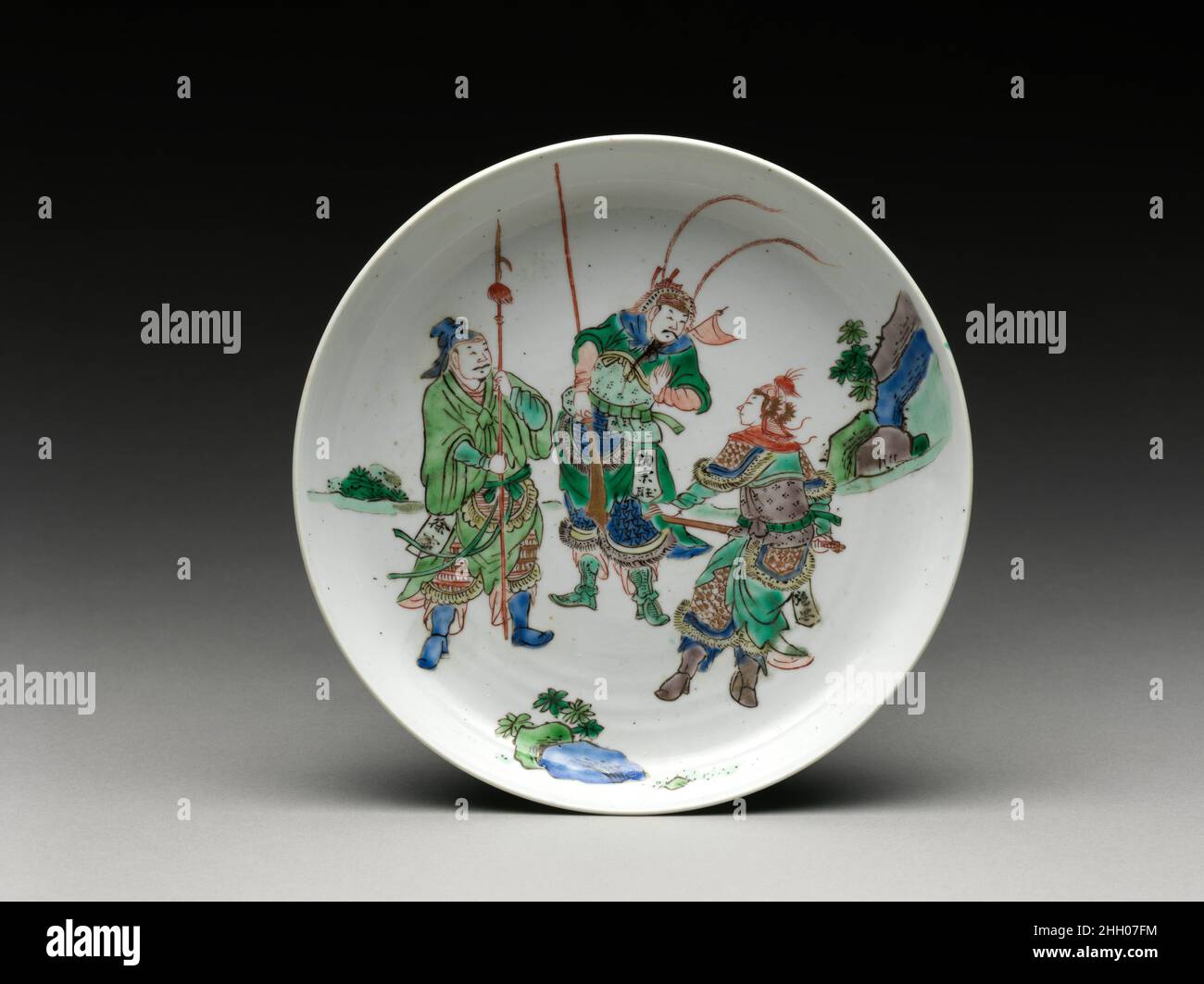 Teller mit drei Helden vom Wasserrand China Kartuschen an den Hüften dieser Figuren nennen sie als Helden aus dem klassischen Roman Water Margin (Shuihu Zhuan), der den Widerstand einer Bande von Gesetzlosen gegen die korrupte Song-Regierung im frühen zwölften Jahrhundert schildert. Der Roman, der Mitte des 16. Jahrhunderts erstmals veröffentlicht wurde, war populär und blieb auch in der Neuzeit so. Figuren und Szenen aus dem Roman wurden wichtige Quellen in der Kunst der Ming- und Qing-Dynastien. Gericht mit drei Helden aus dem Wasser Rand. China. Porzellan mit polychromen Emaillen überglasiert (Jingdezhen Ware). Q Stockfoto