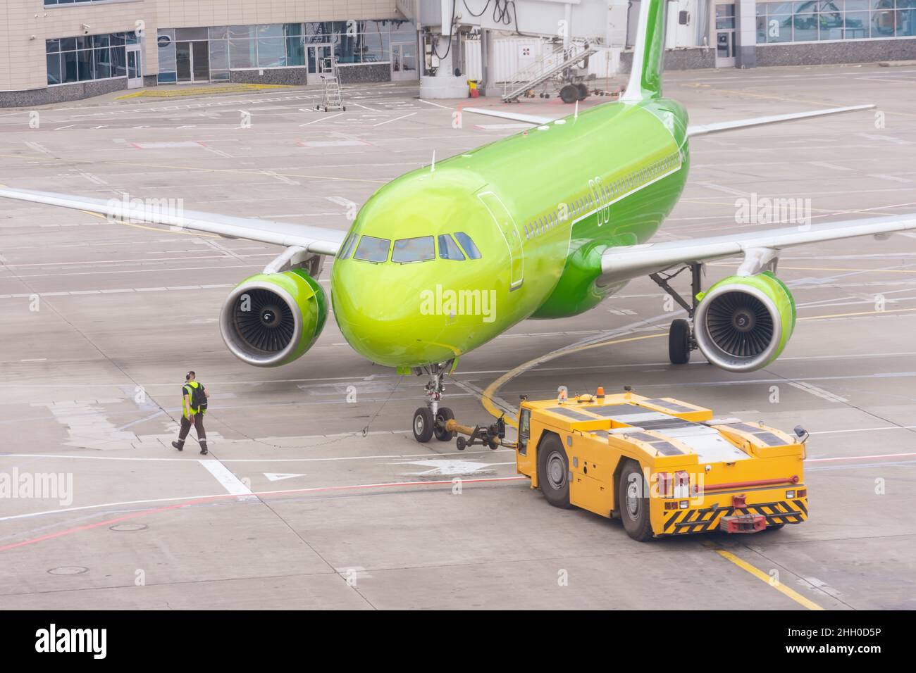 SCHLEPPER mit dem Flugzeug auf dem Vorfeld im Flughafen Stockfoto