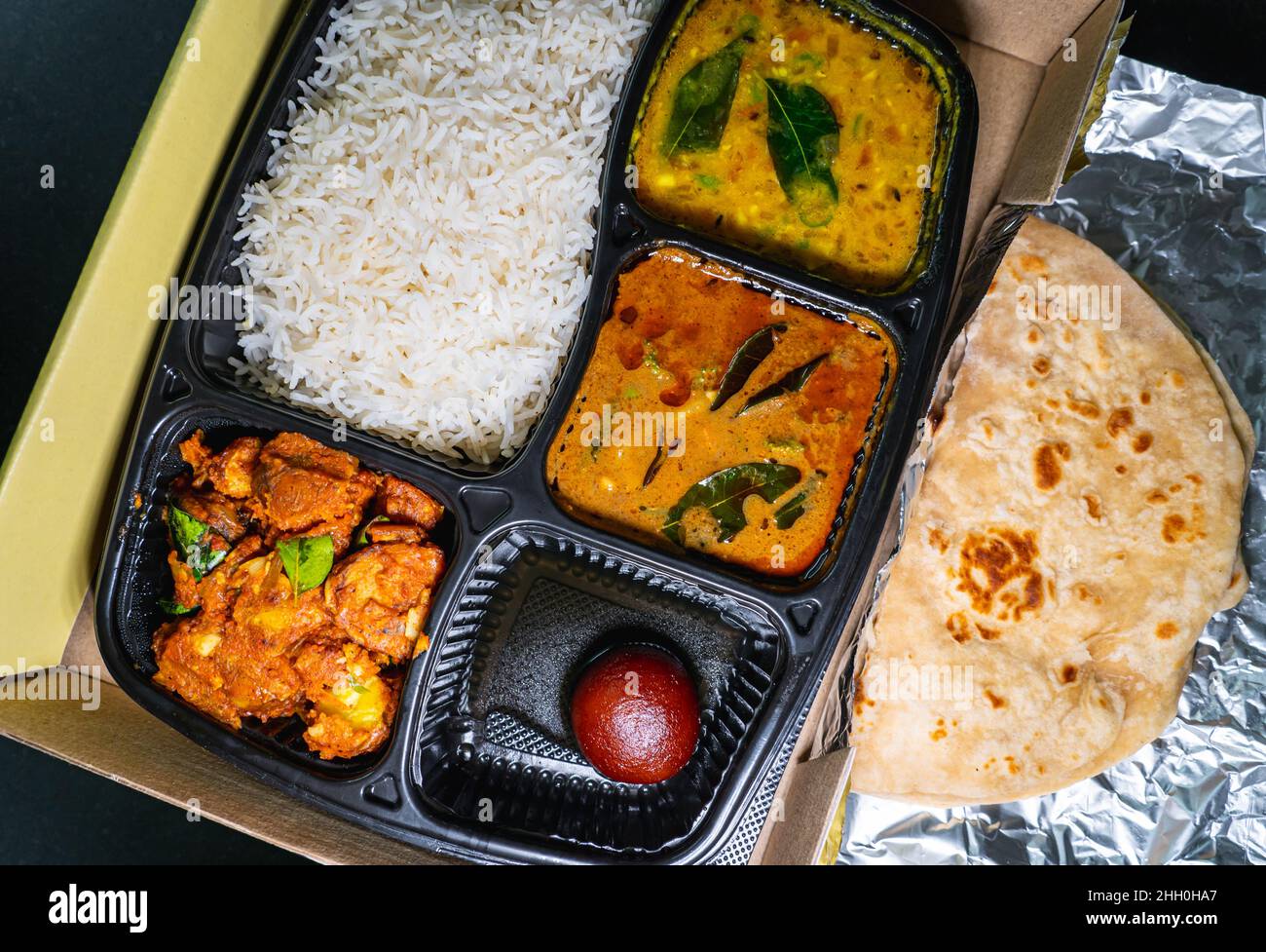 Selektiver Fokus auf eine Vielzahl von indischen Speisen zum Mitnehmen. Stockfoto