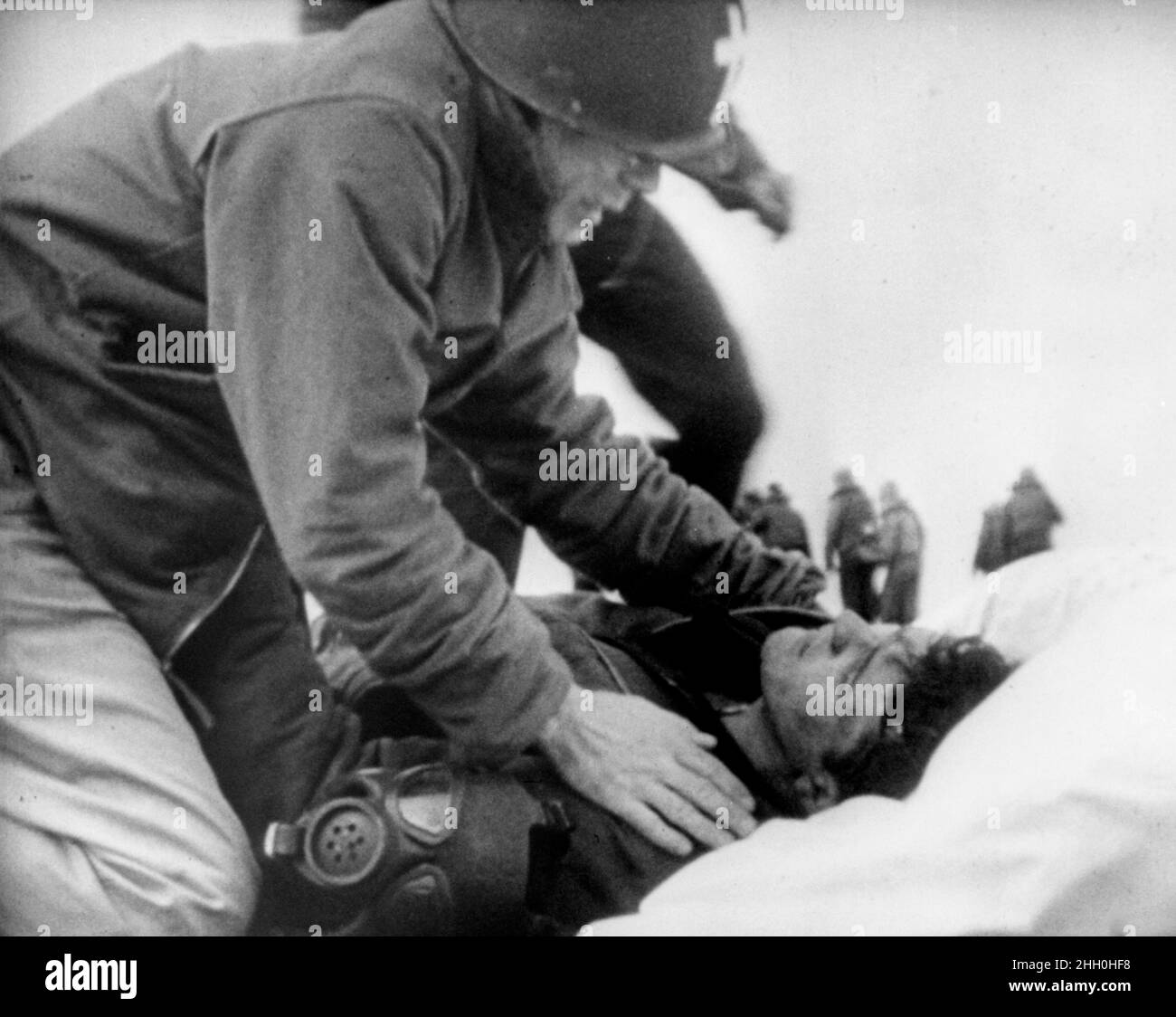 Der Priester Joseph O'Callahan, der einem sterbenden Matrosen die letzten Riten auf dem Flugzeugträger USS Franklin gab, nachdem er am 19th. März 1945 von japanischen Bomben getroffen wurde Stockfoto