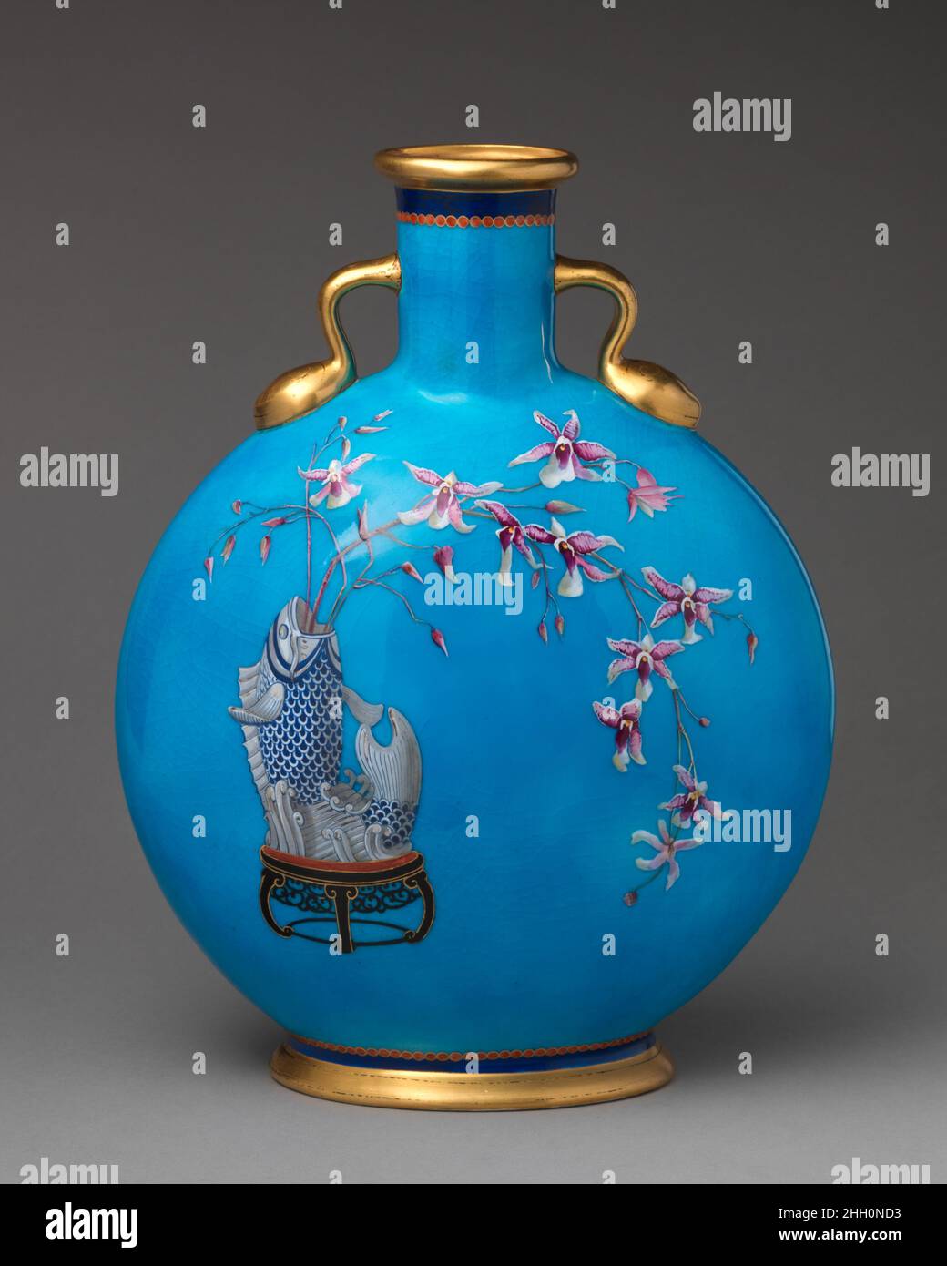 Mondflasche mit Fischvase mit Orchideenspray ca. 1872? Minton(s) Minton war die wichtigste Keramikfabrik in der viktorianischen Zeit und begann, Produkte auf der ersten großen Ausstellung von 1851 auszustellen. Das 1793 von Thomas Minton in Stoke-on-Trent gegründete Unternehmen spezialisierte sich zunächst auf Transferware-Keramik, bevor es ab 1836 unter dem Besitz von Thomas Sohn Herbert Minton expandiert. Unter dem Besitz von Colin Minton Campbell, der 1858 die Nachfolge seines Onkels antrat, wurde die Fabrik als Spezialhersteller von Feinsteinzeug der Aesthetik-Bewegung anerkannt, das von einem r inspiriert wurde Stockfoto