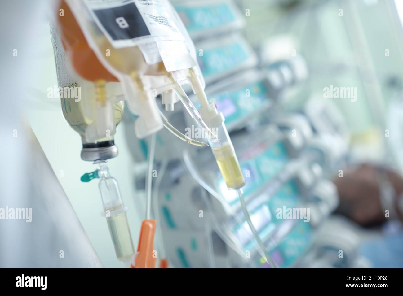 Intravenöser Tropf auf dem Hintergrund des Patienten im Bett. Stockfoto