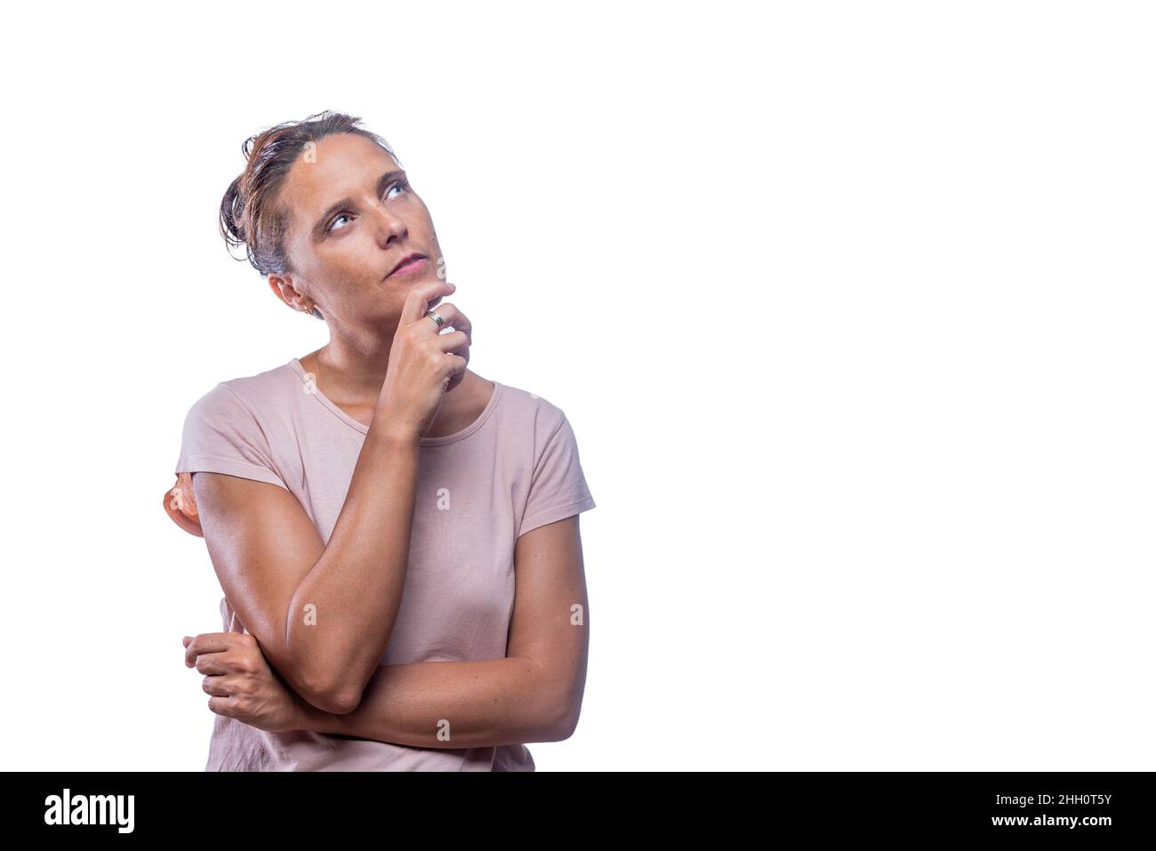 Eine nachdenkliche Frau, die auf einem weißen Hintergrund aufsteht Stockfoto