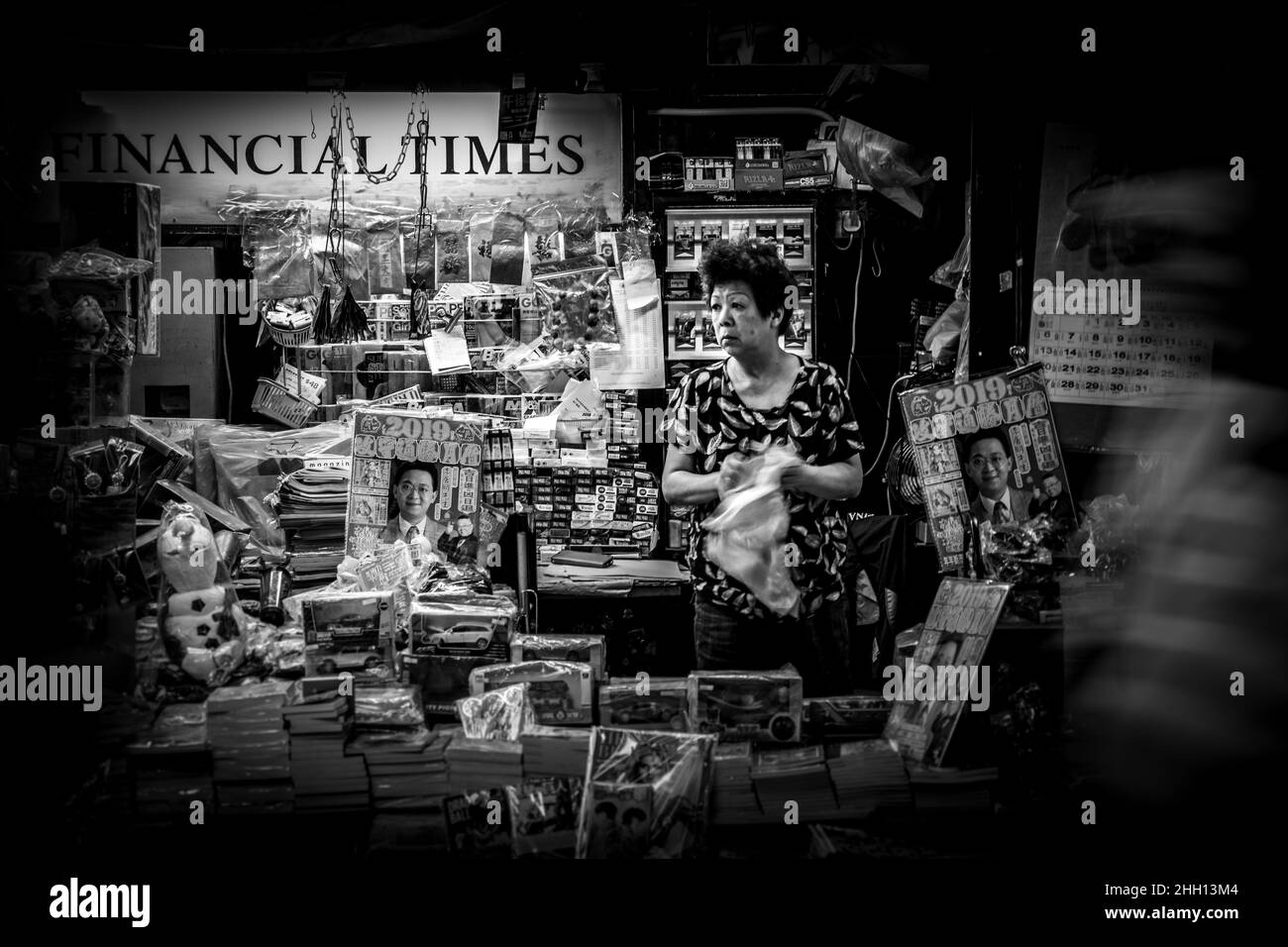 Menschen, die an einem Zeitungsstand in Hongkong vorbeikommen Stockfoto