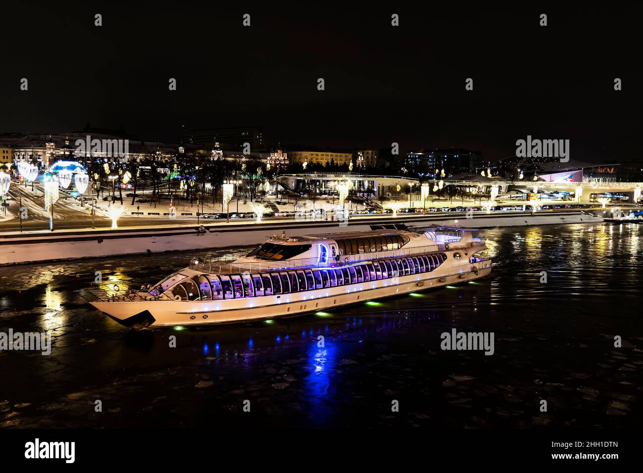 Blick auf den Fluss Moskau, das Touristenboot und den Damm bei der Weihnachtsbeleuchtung. Stockfoto