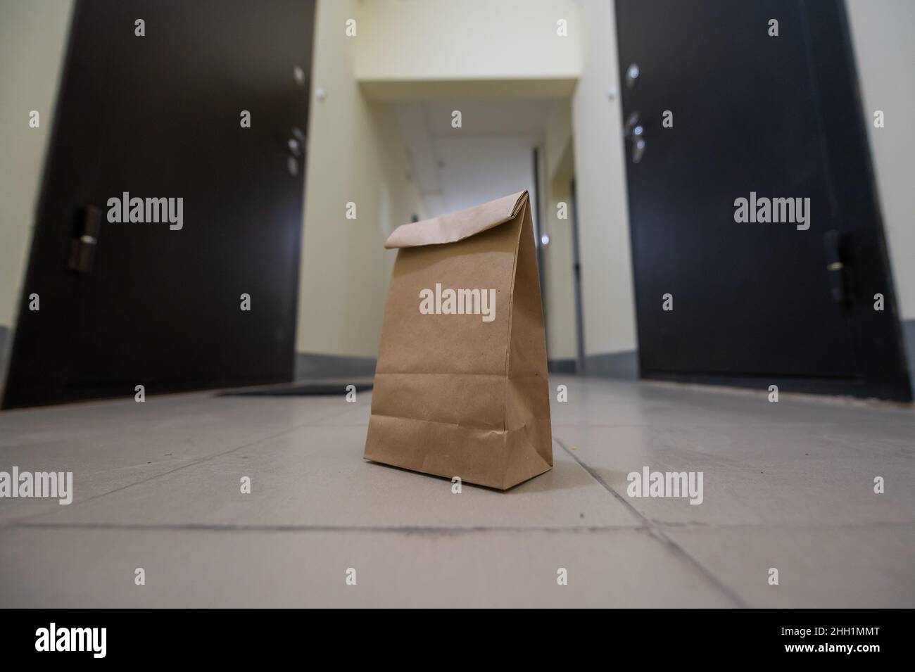 In der Lobby vor der Haustür der Wohnung steht eine Öko-Papiertüte. Kontaktlose Lebensmittelversorgung für die Epidemie. Der Kurier hat ein Online-Formular verlassen Stockfoto