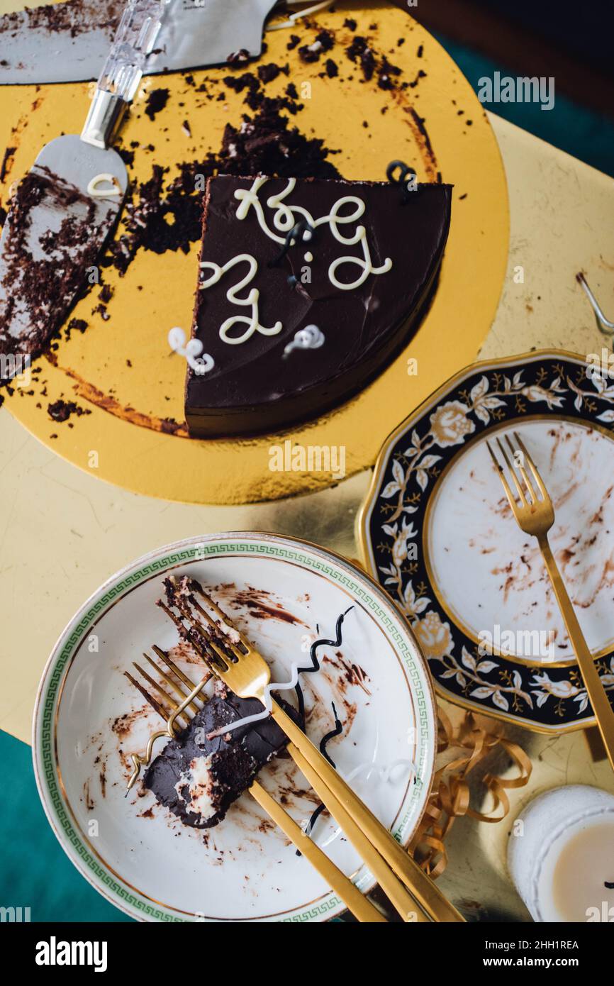 Nach dem Geburtstag Party Chaos mit Schokoladenkuchen und Gold Stockfoto