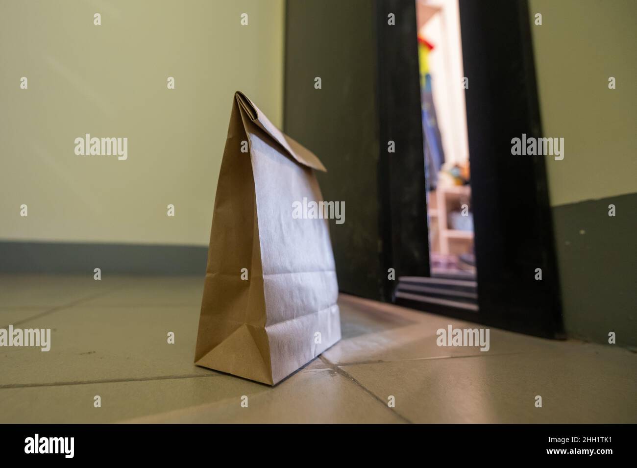 In der Lobby vor der Haustür der Wohnung steht eine Öko-Papiertüte. Kontaktlose Lebensmittelversorgung für die Epidemie. Der Kurier hat ein Online-Formular verlassen Stockfoto