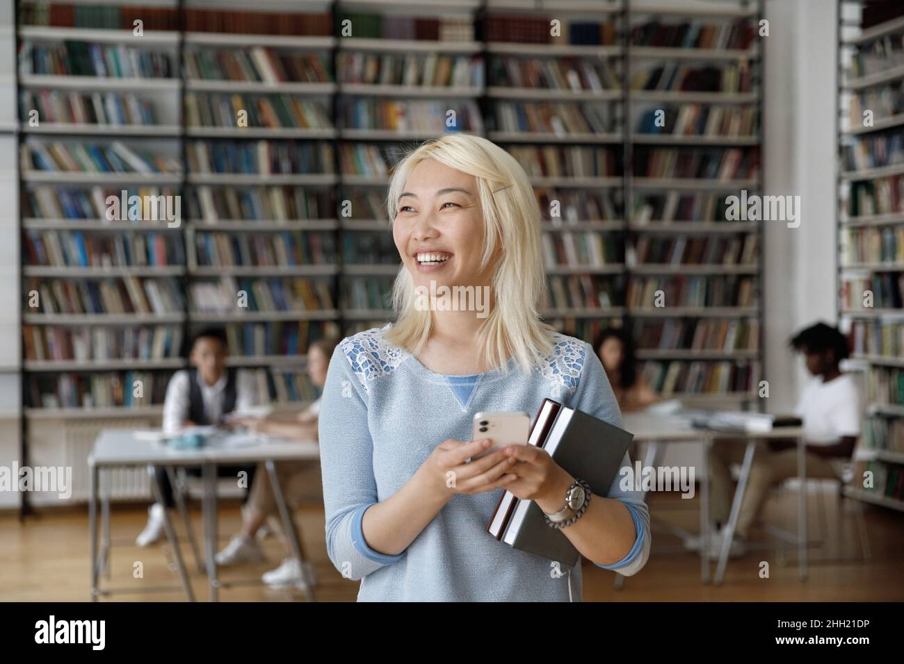 Glücklich lachend blonde frisch asiatische Student Mädchen mit Online-Service Stockfoto