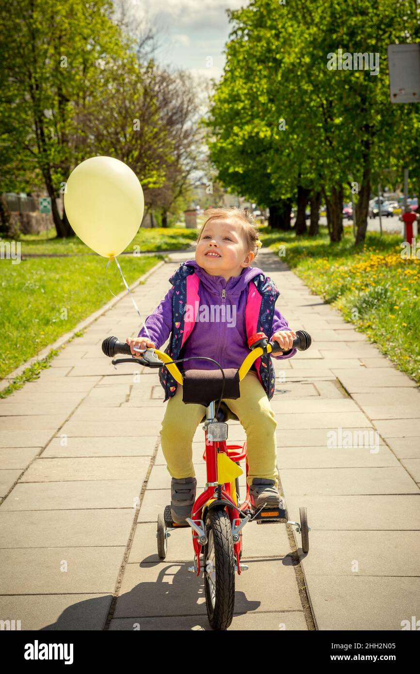 Glückliches 3 Jahre altes Mädchen, das Fahrrad fährt Stockfoto