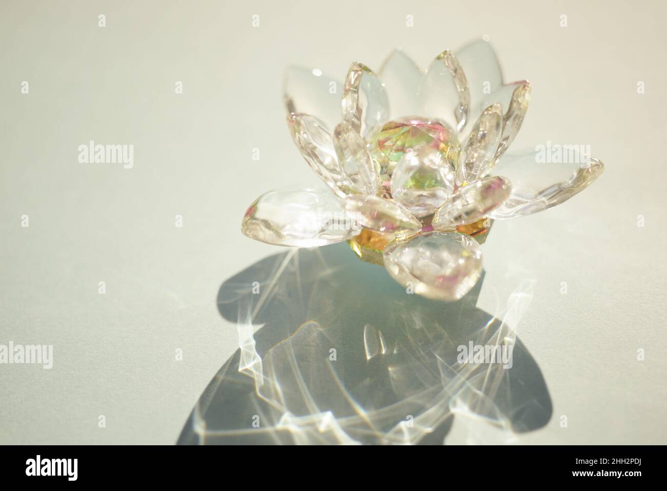 Wunderschöne Lotusblume aus Kristall auf einem grünen sonnigen Tisch. Stockfoto