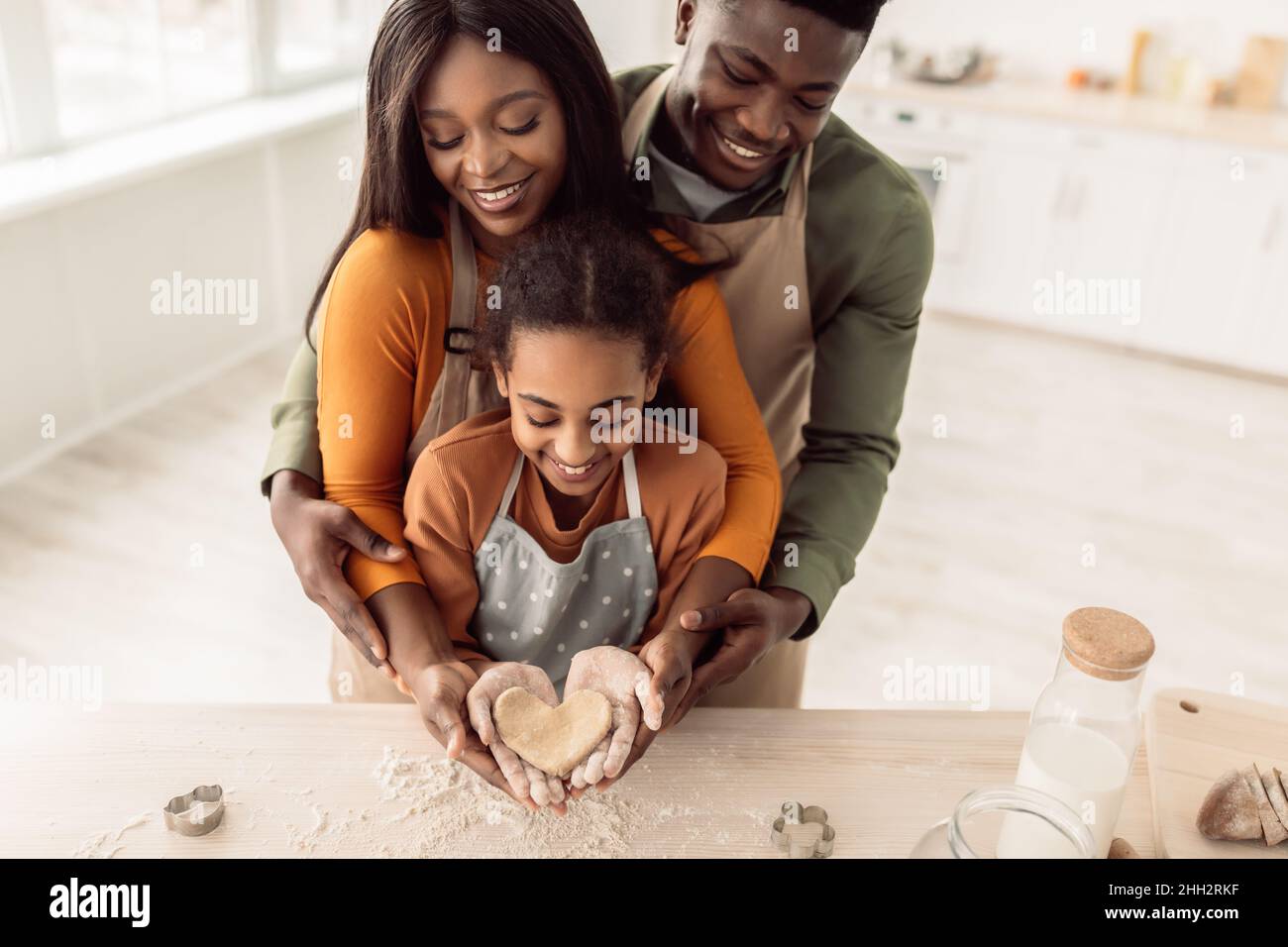 Afrikanische Familienbacken Halten Sie Herzförmigen Teig In Den Händen In Der Küche Stockfoto