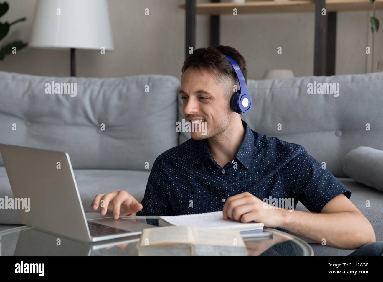Lächelnder junger Mann, der auf Online-Kursen studiert. Stockfoto