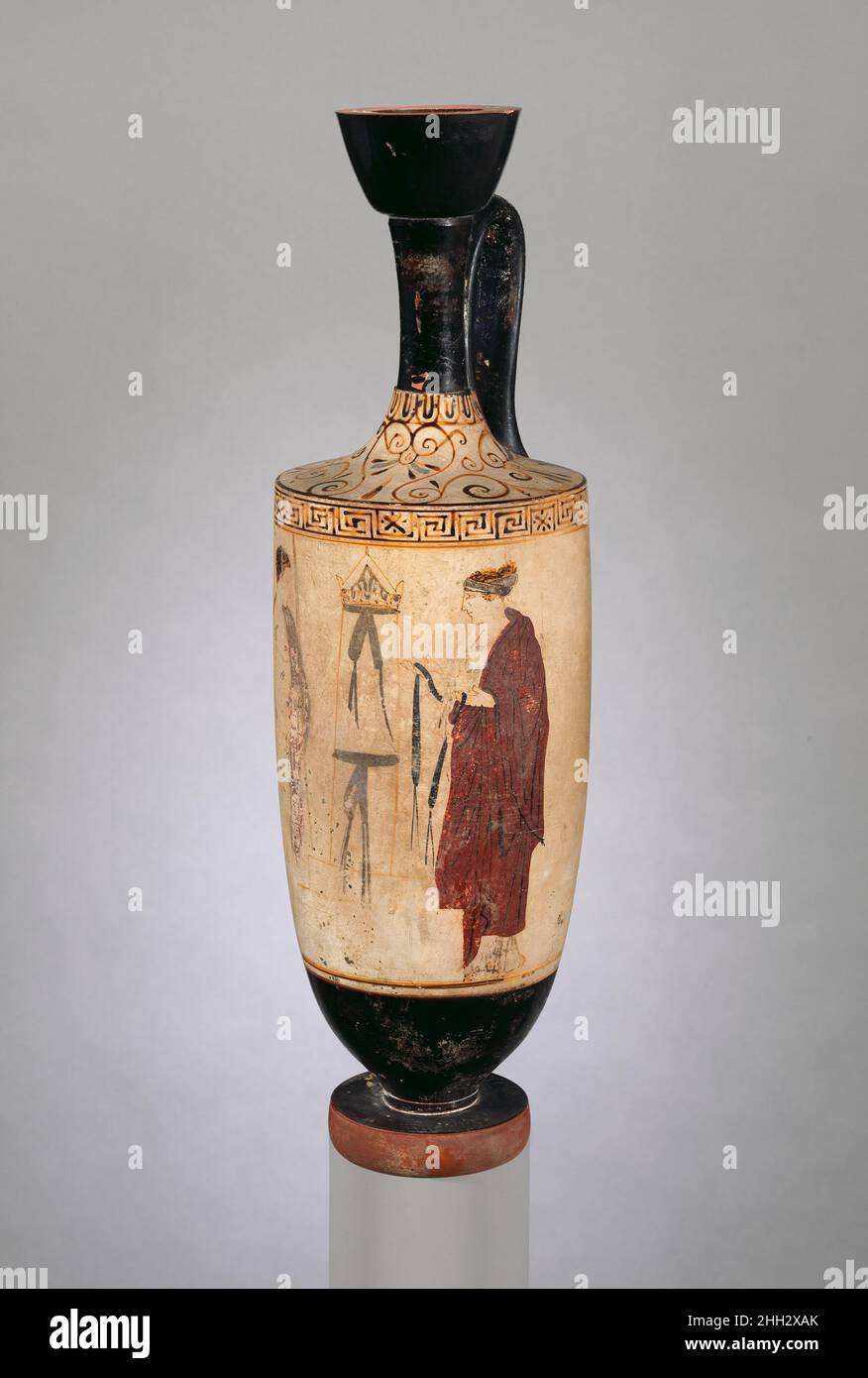 Terrakotta-Lekithos (Ölflasche) ca. 450–440 v. Chr. einem Künstler zugeschrieben, der mit dem Achilles-Maler in Verbindung steht Jugend und Frau an einem GrabenDie Achilles- und Phiale-Maler waren die führenden Künstler in einer Werkstatt, zu der eine Reihe von Persönlichkeiten gehörten, von denen einige schärfer definiert sind als andere. Während der Maler dieser Vase unbestimmt bleibt, wird seine Zugehörigkeit zur Werkstatt durch die Ornamente, die auf der Schulter der Vase und an der Oberseite des Körpers erscheinen, angezeigt. Terrakotta-Lekithos (Ölflasche). Griechisch, Dachboden. Ca. 450–440 V. CHR. Terrakotta, weißer Boden. Klassisch. Vasen Stockfoto