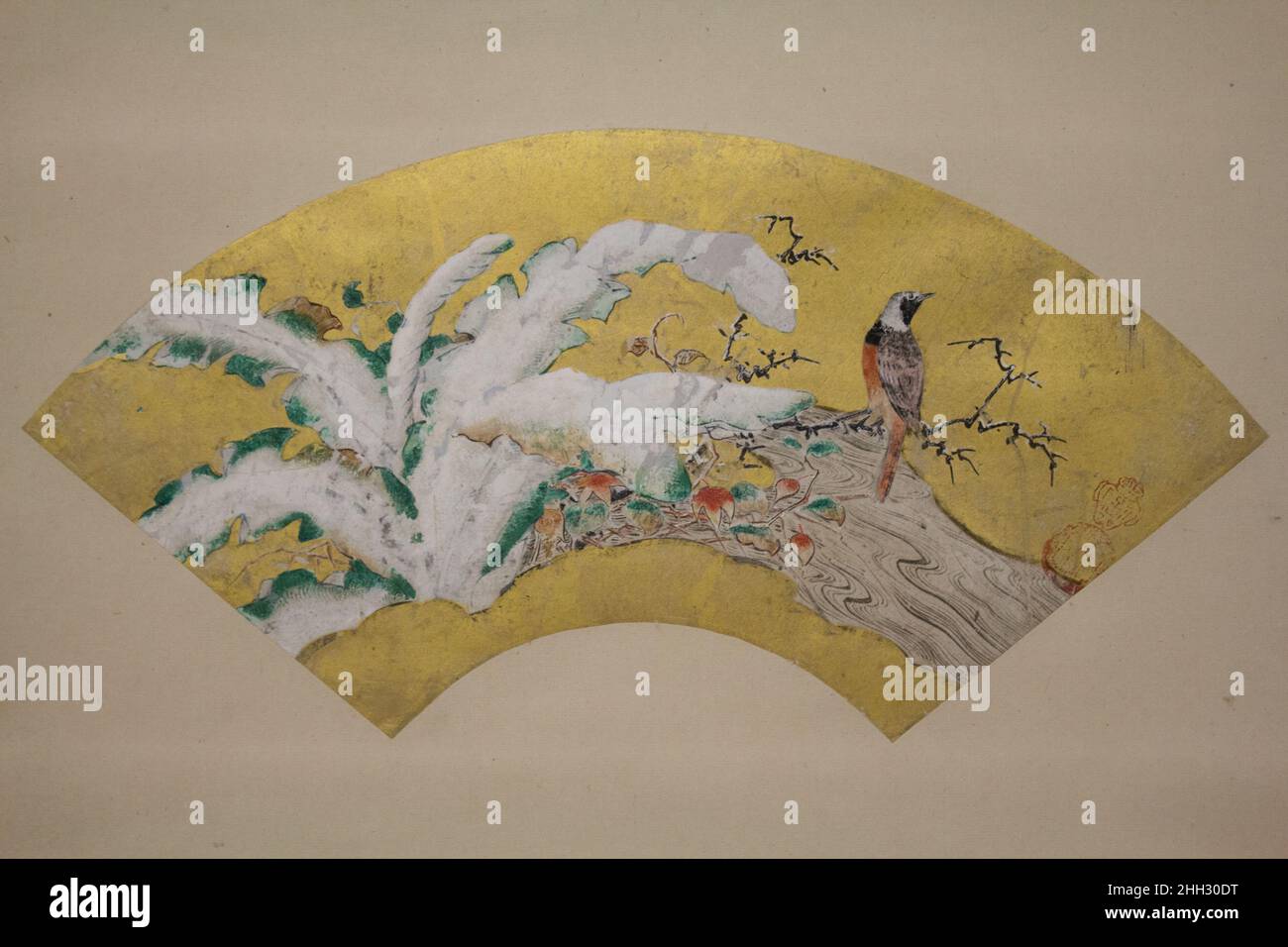 Wegerich und Vogel im Schnee Ende 16th Jahrhundert Kano S?sh? ???? Auf diesem fächerförmigen Gemälde von Kano S?sh?, dem jüngeren Bruder des Leiters der Kano-Schule in dritter Generation, Kano Eitoku (1543–1590), steht ein Vogel auf dem blattlosen Ast eines alten Baumes über einem Bach neben einem Gewirr chinesischer Laternenpflanzen, Schilf, Und einen Wegerich, dessen breite Blätter mit schwerem, frühem Winterschnee beladen sind. Mit Ausnahme der Farblinien des fließenden Stromes und einer geringen Anzahl der Blätter der chinesischen Laterne werden die meisten Motive auf eine Schicht schalenweißen Pigments (Gofun) gemalt, die direkt aufgetragen wird Stockfoto