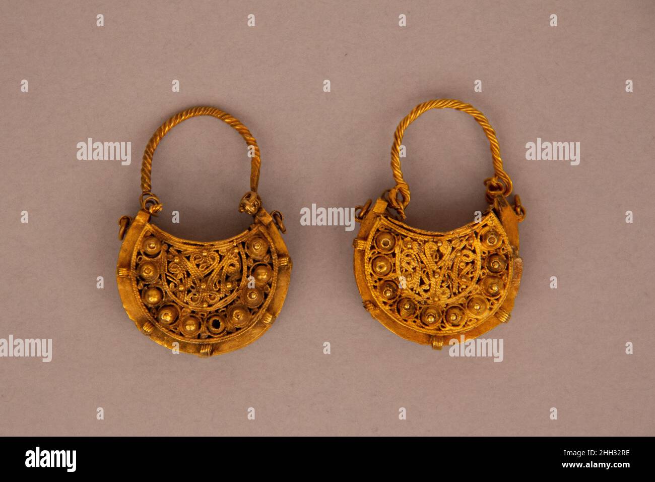 Ohrring, einer von einem Paar 11th Jahrhundert Diese halbmondförmigen (hilal) goldenen Ohrringe wurden mit filigranem Durchbrochene, Perlen Granulation und mehrere Schleifen rund um den Umfang und das Innere, die einst Edelsteine befestigt hergestellt. Diese Merkmale, zusammen mit dem hemisphäre Ornament, sind typisch für den opulenten Schmuck aus der Fatimiden-Zeit (909–1171). Die Fatimiden regierten ein Königreich, das sich über Nordafrika, die Levante und Hijaz erstreckte und bis nach Nubia, dem heutigen Sudan, reichte, wo sie die Kontrolle über die wichtigen Goldminen behielt, die die für die Herstellung der Goldmine erforderlichen Rohstoffe lieferten Stockfoto
