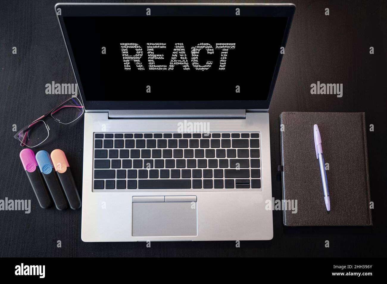 Draufsicht des Laptops mit Text Reagieren. Reagieren Sie die Beschriftung auf dem Laptop-Bildschirm und der Tastatur. Lernen Sie React-Sprache, Computerkurse, Schulungen. Stockfoto