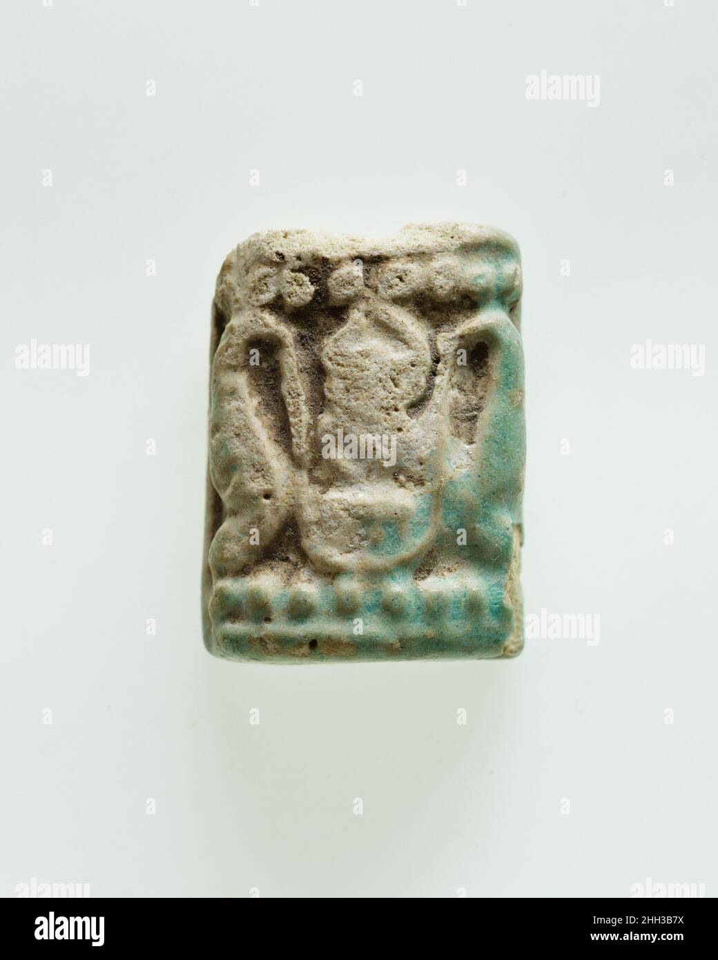 Plakette mit geflügelten Re-Harakhty Ca. 1295–1070 v. Chr. Neues Königreich die Oberseite dieser rechteckigen Gedenktafel ist mit einem Paar Uraei verziert, das durch ihre Schwänze verbunden ist und eine unvollständige Version des Thronnamens von Thutmose III, (Men)kheperre, flankiert. Trotz des Namens des Herrschers aus der frühen 18th. Dynastie wurde diese Tafel nach seiner Herrschaft geschnitzt, wie die Perlenseilen an der Ober- und Unterseite erkennen lassen. Dieses dekorative Merkmal war auf Plaketten üblich, die während der Dynastie 19–21 hergestellt wurden. Das spätere Datum wird auch durch die Dekoration auf der Unterseite des Amuletts bestätigt, die eine einflügelige Gottheit mit Falkenkopfst zeigt Stockfoto