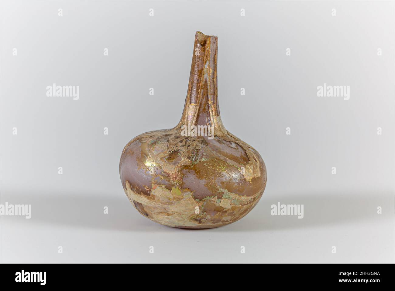 Parfümflasche aus Glas Anfang bis Mitte des 1st. Jahrhunderts n. Chr. römisch Durchscheinend hellviolett; opake weiße Trails.schlanker Hals, nach unten ausdehnend; hockiger, bauchiger Körper; leicht konkaver Boden.marverierte Traildekoration auf den Boden aufgetragen, spiralförmig nach oben gewickelt und über Körper und Hals in ein wellenförmiges Muster gezogen.Body komplett, aber ohne Rand und Hals; Nadelstich Blasen; Lochfraß, Abstumpfen, und Flecken von brillant schillernden Verwitterung.. Parfümflasche aus Glas. Römisch. Früh–Mitte des 1st. Jahrhunderts n. Chr. Glas; geblasen und gezogen. Frühkaiserlich. Glas Stockfoto