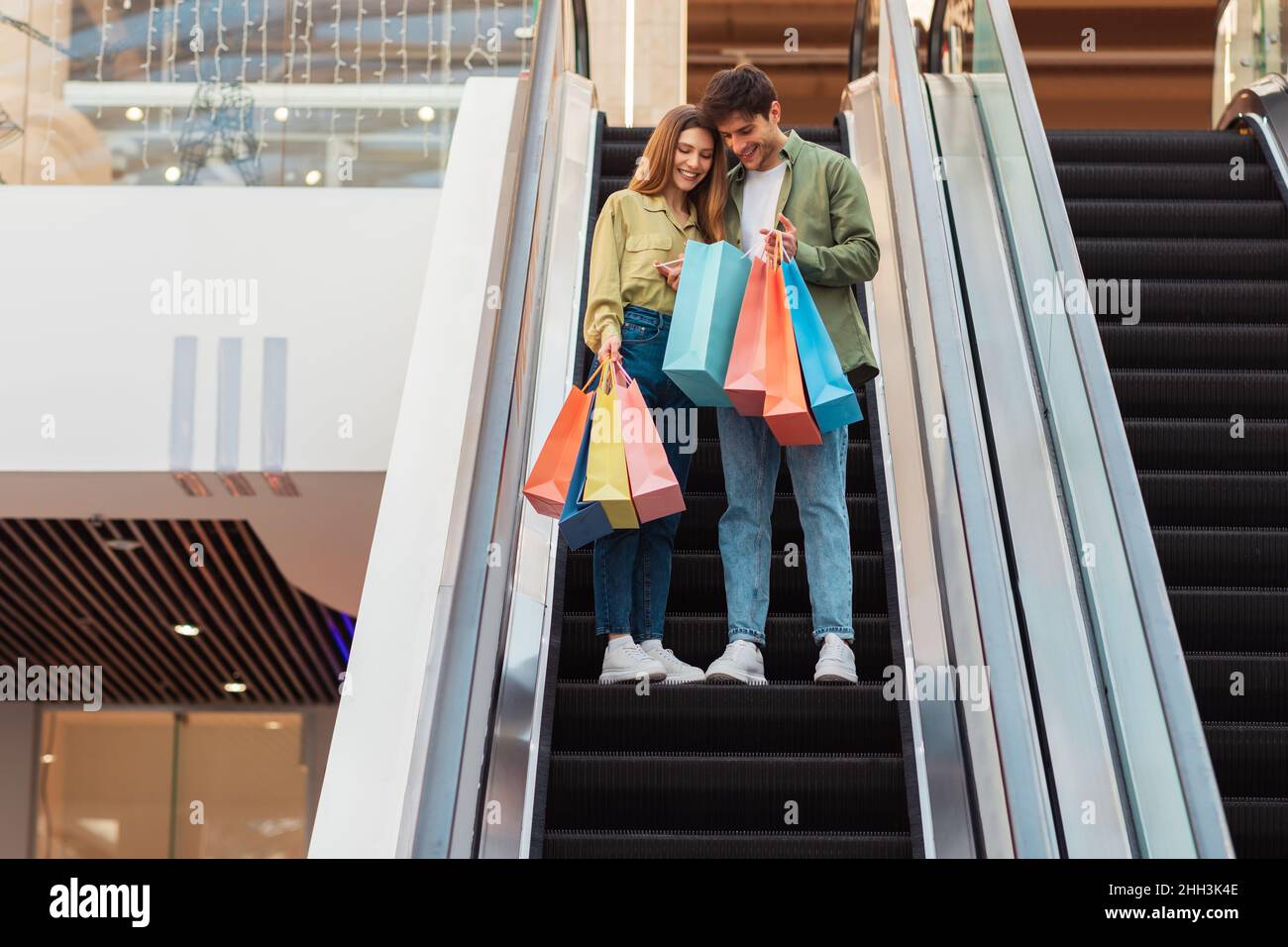 Glückliches Paar Beim Einkaufen Stehen Auf Einer Beweglichen Treppe In Der Mall Stockfoto