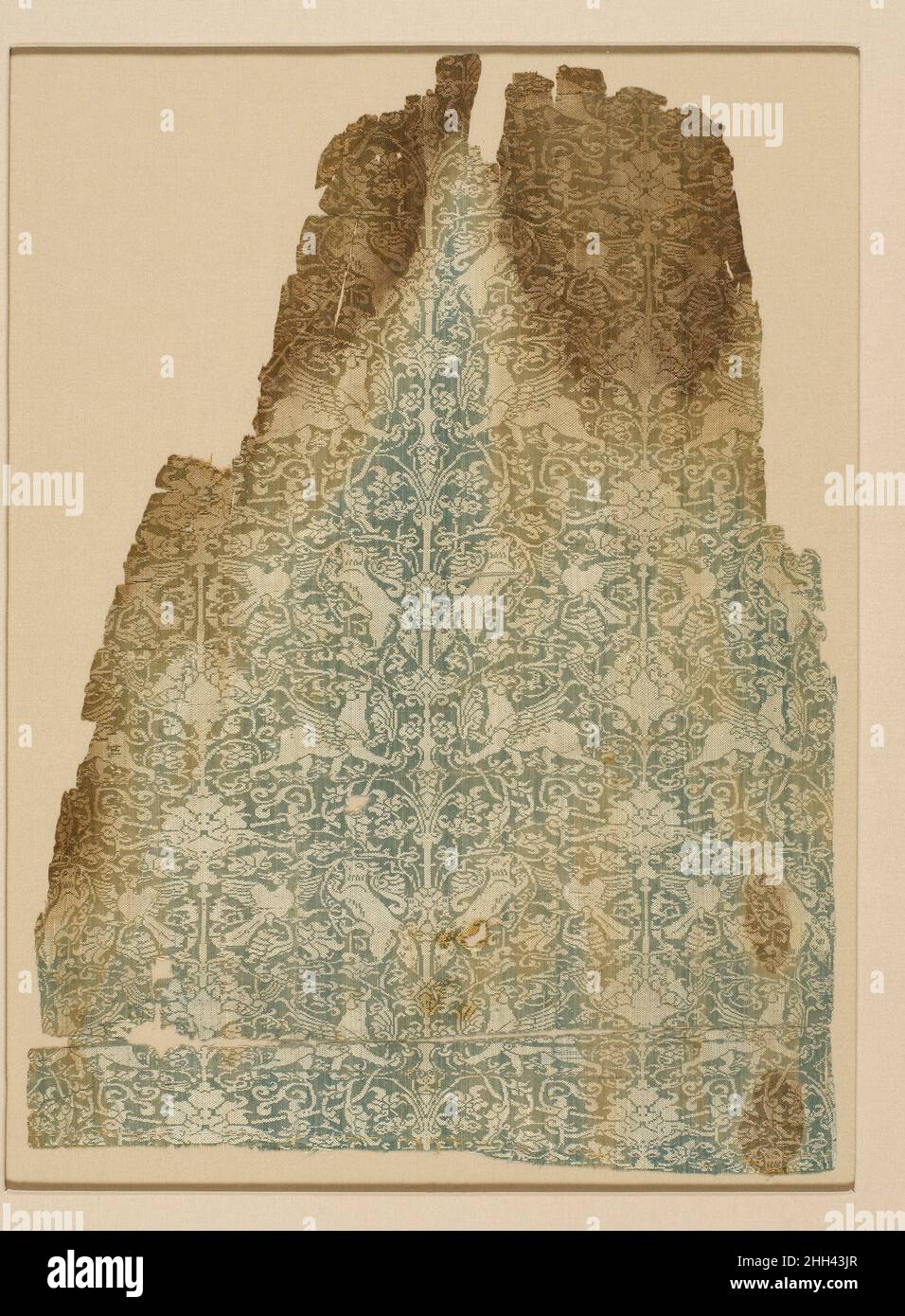 Textil 13th. Jahrhundert das komplizierte Muster auf diesem Textil weist Greifen, Füchse und Vögel auf, die zwischen Weinrollen und Palmettenbäumen angeordnet sind. Die Ähnlichkeit der Motive, des Designs und der Technik mit früheren Textiltraditionen im östlichen Iran deutet auf eine Migration der Handwerker nach Westen als Reaktion auf die mongolische Expansion hin. Mehrere Sammlungen bewahren Fragmente des gleichen Textils, vielleicht Teil einer Tunika. Textil 450741 Stockfoto