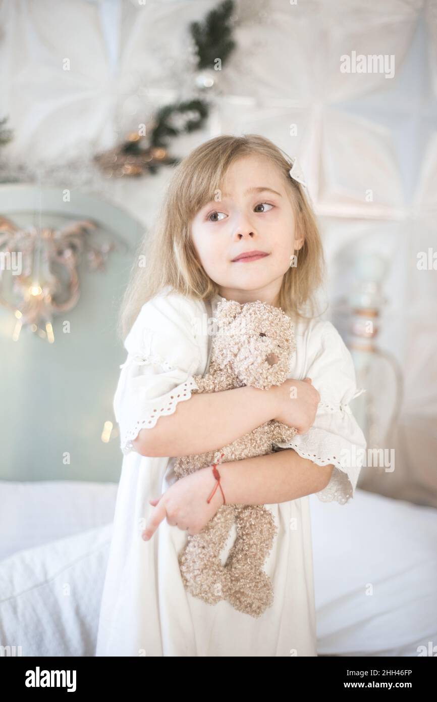 Das kleine Mädchen und ihr Teddybär am Morgen im Schlafzimmer. Retro-Style. Stockfoto