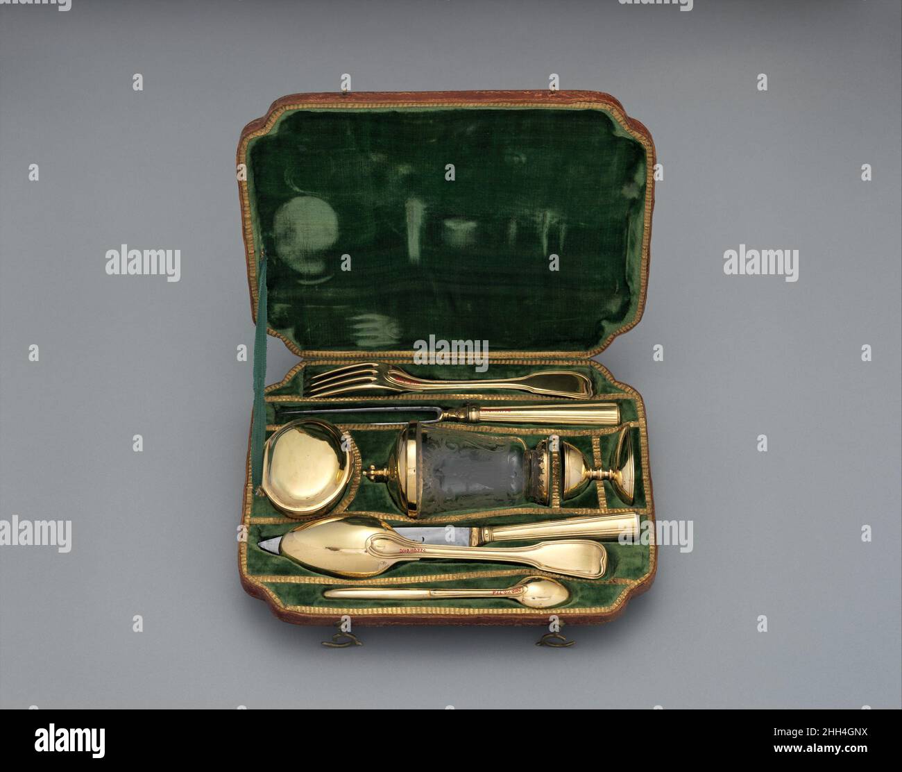 Reisestet mit Glasbecher in Case 1777–79 Samuel Bardet Deutsch einige Mitglieder der souveränen Dynastien Mittel- und Südosteuropas reisten nie ohne ihr Besteck-Set. Das schien den französischen Höflingen eine seltsame Gewohnheit zu sein, die im späten 17. Und 18. Jahrhundert ihre Messer am Tisch teilten. Doch in einer Zeit, in der ein wenig tödliches Arsen mit Salz oder Gewürzen einen großen Weg gehen würde, hatte der ungarische Adel Grund zu ihrer Vorsicht; Vergiftungen, vor allem durch Arsen, gemischt mit Salz oder Gewürzen, waren keine Seltenheit. Augsburger Silberschmiede waren bekannt f Stockfoto