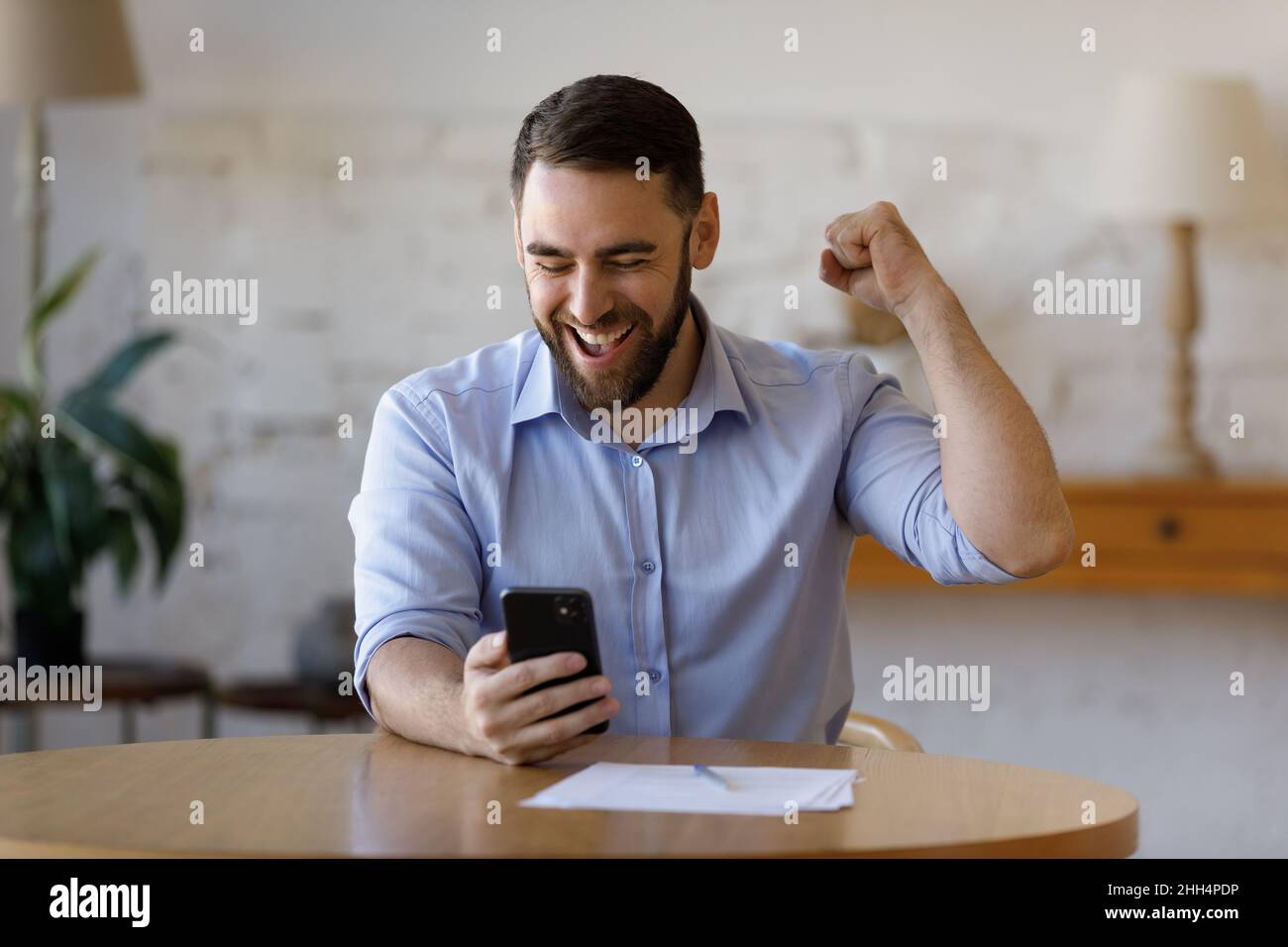 Glücklicher, begeisterter Smartphone-Nutzer, der Erfolg, Erfolg und Erfolg genießt Stockfoto