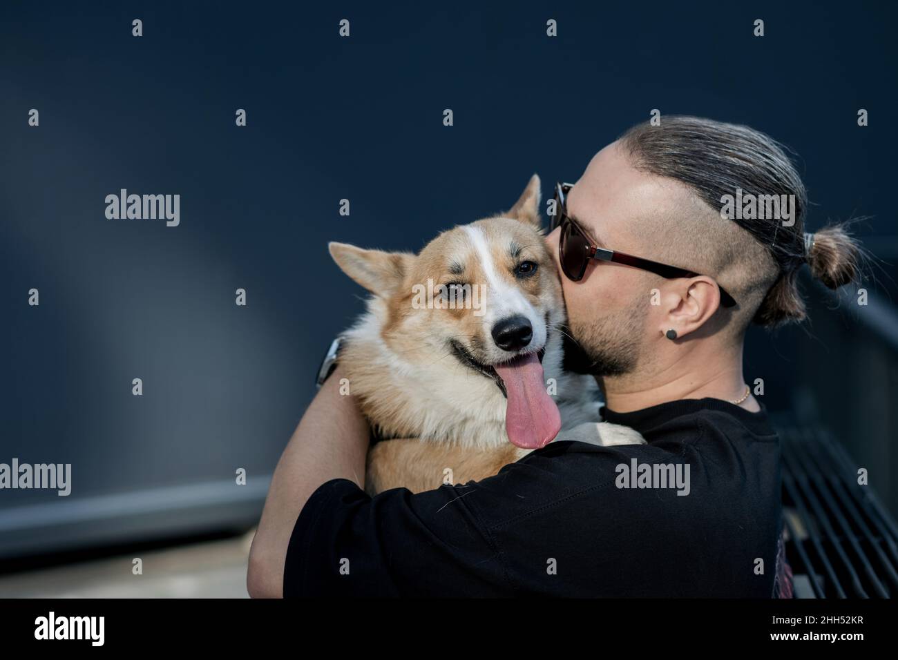 Portrait hübscher junger Hipster-Mann, der seinen guten Freund Hund küsst. Positive menschliche Emotionen, Gesichtsausdruck, Gefühle. Speicherplatz kopieren Stockfoto