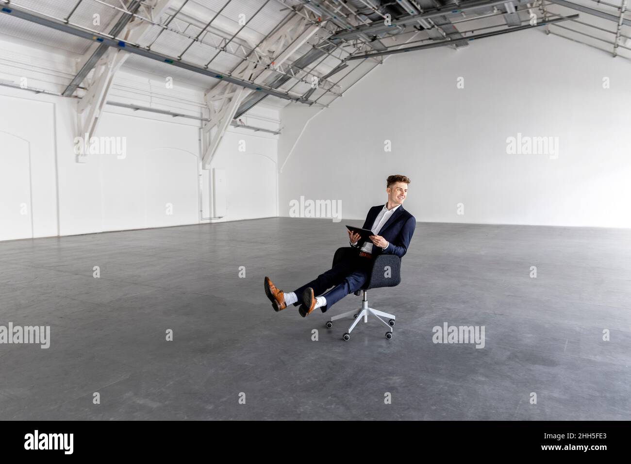 Geschäftsmann mit Tablet-PC auf dem Stuhl Stockfoto