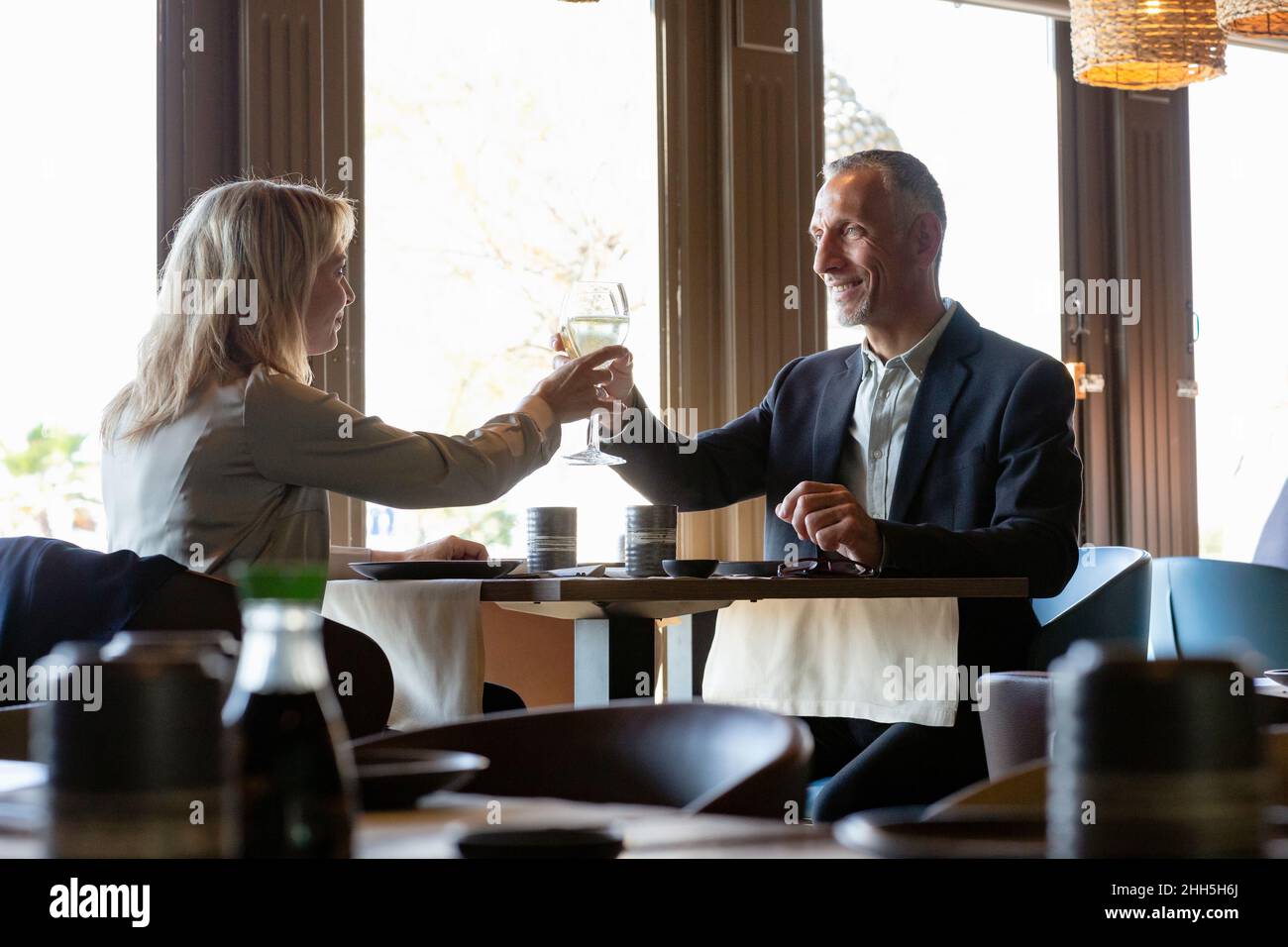 Ein Paar toaste Champagner-Gläser beim Mittagessen im Restaurant Stockfoto