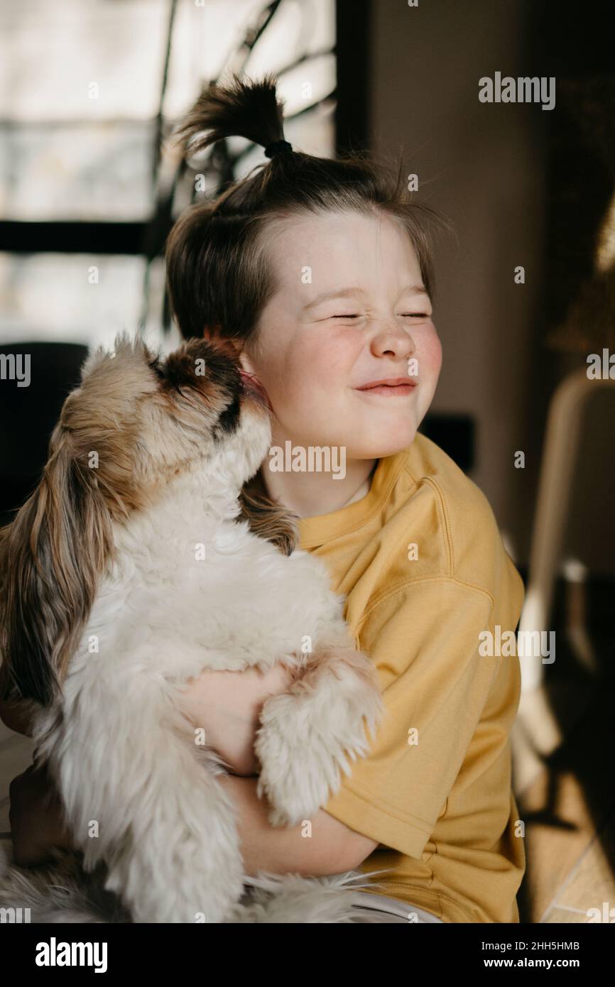 Hund leckt die Wange des Jungen zu Hause Stockfoto