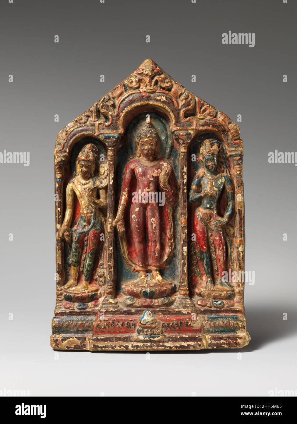 Buddha mit Bodhisattvas Padmapani und Vajrapani Ca. Tibet des 10th. Jahrhunderts dieser frühe, aus Ton geformte Schrein, eines der vollständigsten Beispiele aus Tibet des 10. Jahrhunderts, stellt die drei vorherrschenden Gottheiten des frühen tibetischen Buddhismus dar. Ein Sanskrit Ye Dharma Vers in tibetischer Schrift schmückt die Basis, zusammen mit dem Motiv der drei Juwelen. Der italienische Tibeter Giuseppe Tucci erwarb das Werk im Kloster Tsaparang Anfang 1930s. Buddha mit Bodhisattvas Padmapani und Vajrapani. Tibet. Ca. 10th Jahrhundert. Gebrannter Ton, geformt und polychromiert. Skulptur Stockfoto