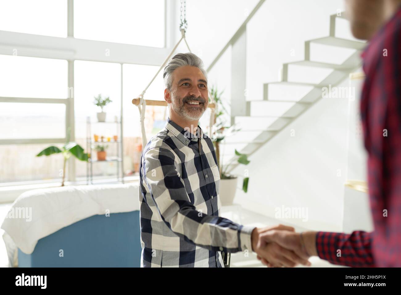 Immobilienmakler schüttelt sich die Hände mit dem Kunden zu Hause Stockfoto