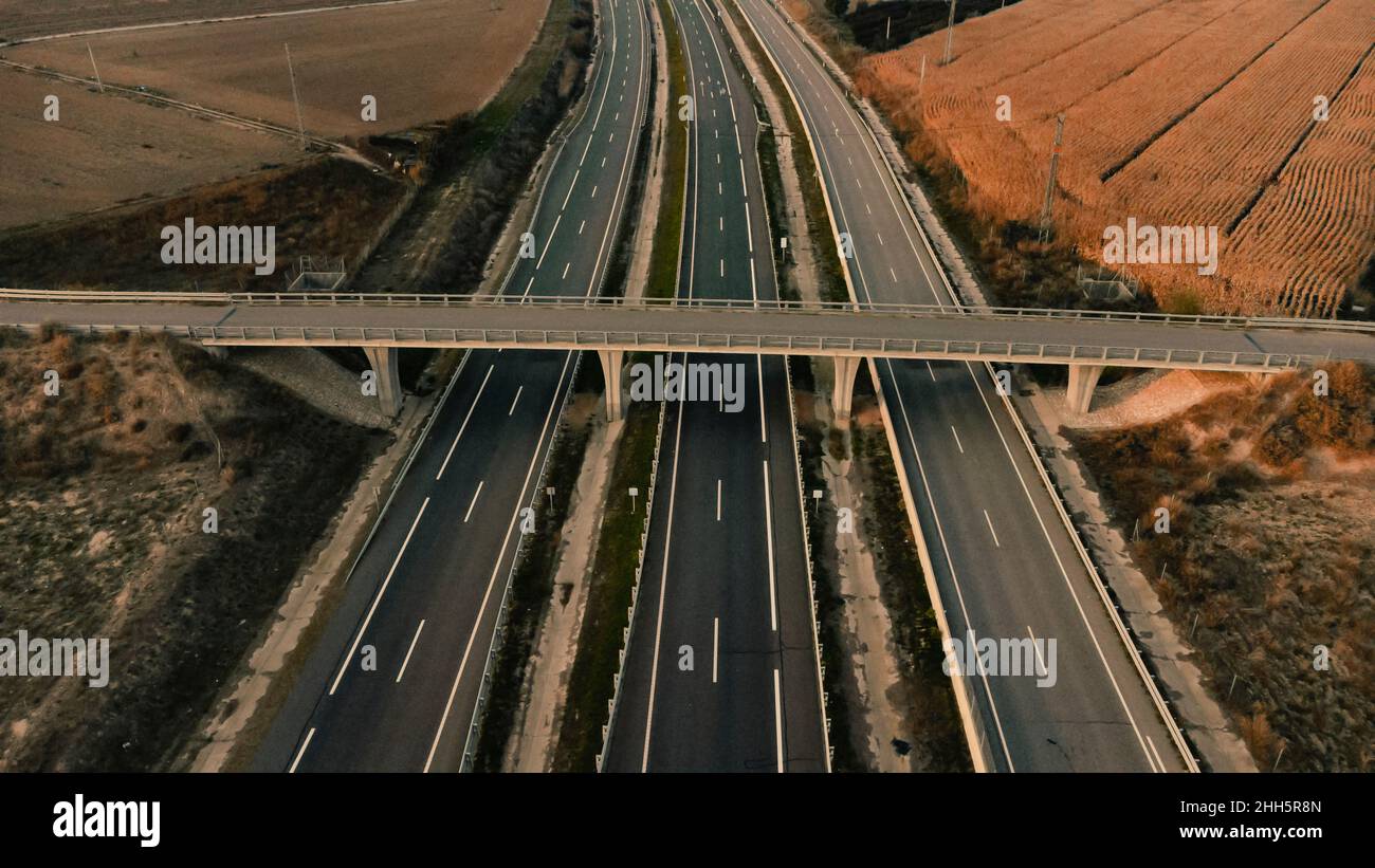 Leere Brücke über die Autobahn, die an einem landwirtschaftlichen Feld in Lleida, Spanien, vorbeiführt Stockfoto