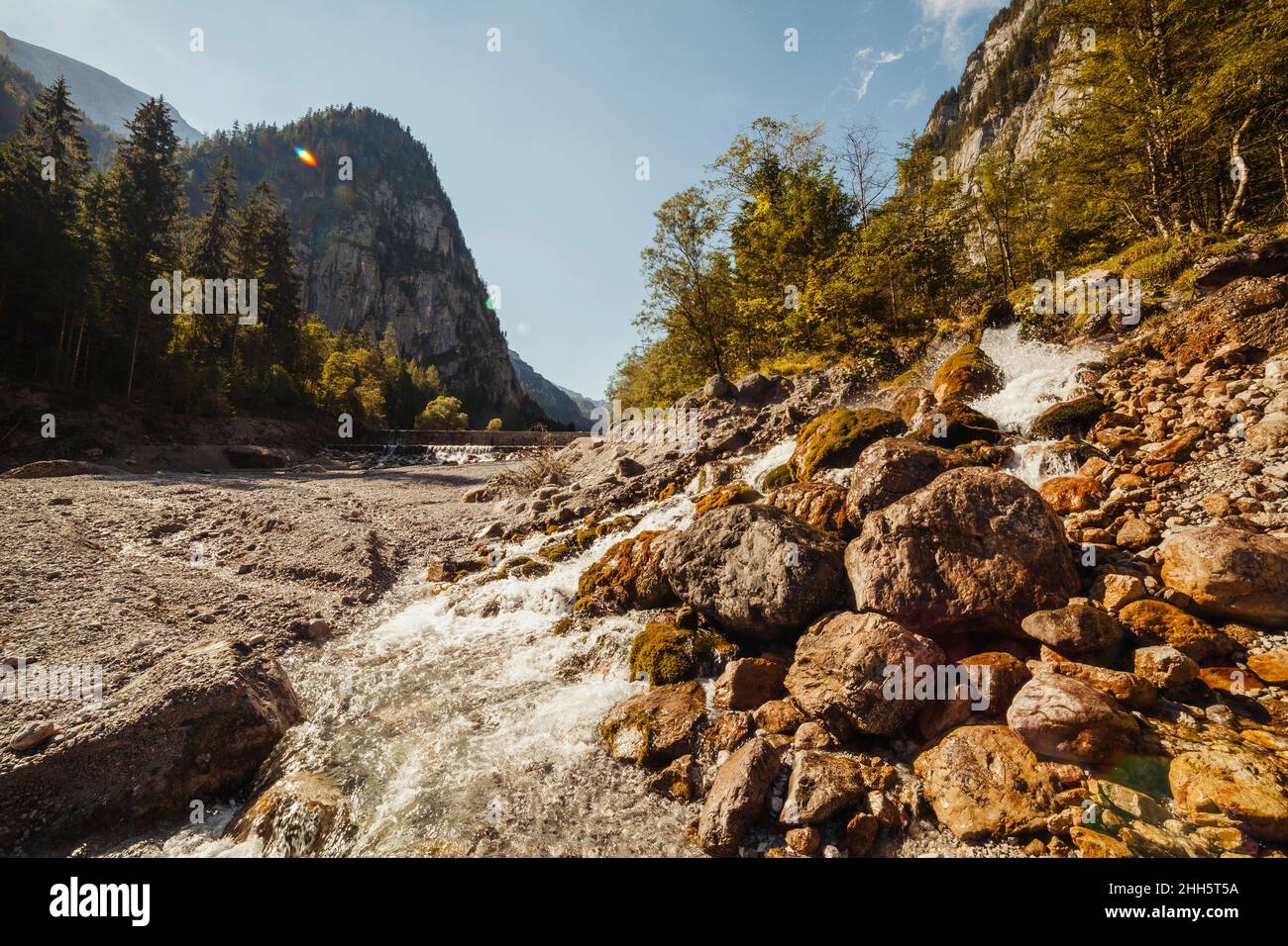 Alpenbach fließt zwischen Felsen Stockfoto